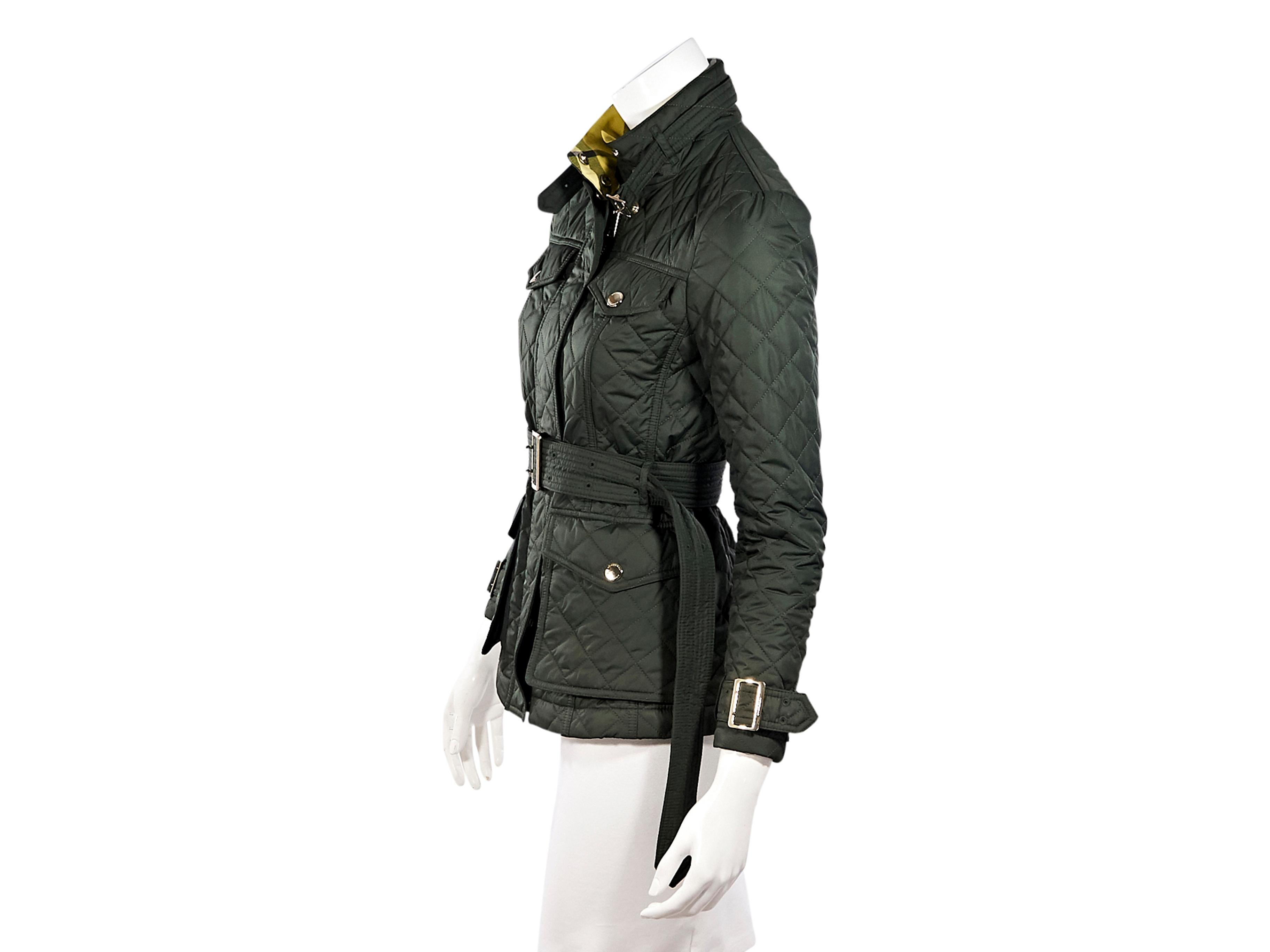 Product details:  Sage green quilted jacket by Burberry.  Stand collar with adjustable buckle.  Long sleeves.  Adjustable buckle cuffs.  Concealed zip-front closure.  Chest and waist snap flap pockets.  Adjustable belted waist.  Goldtone hardware. 