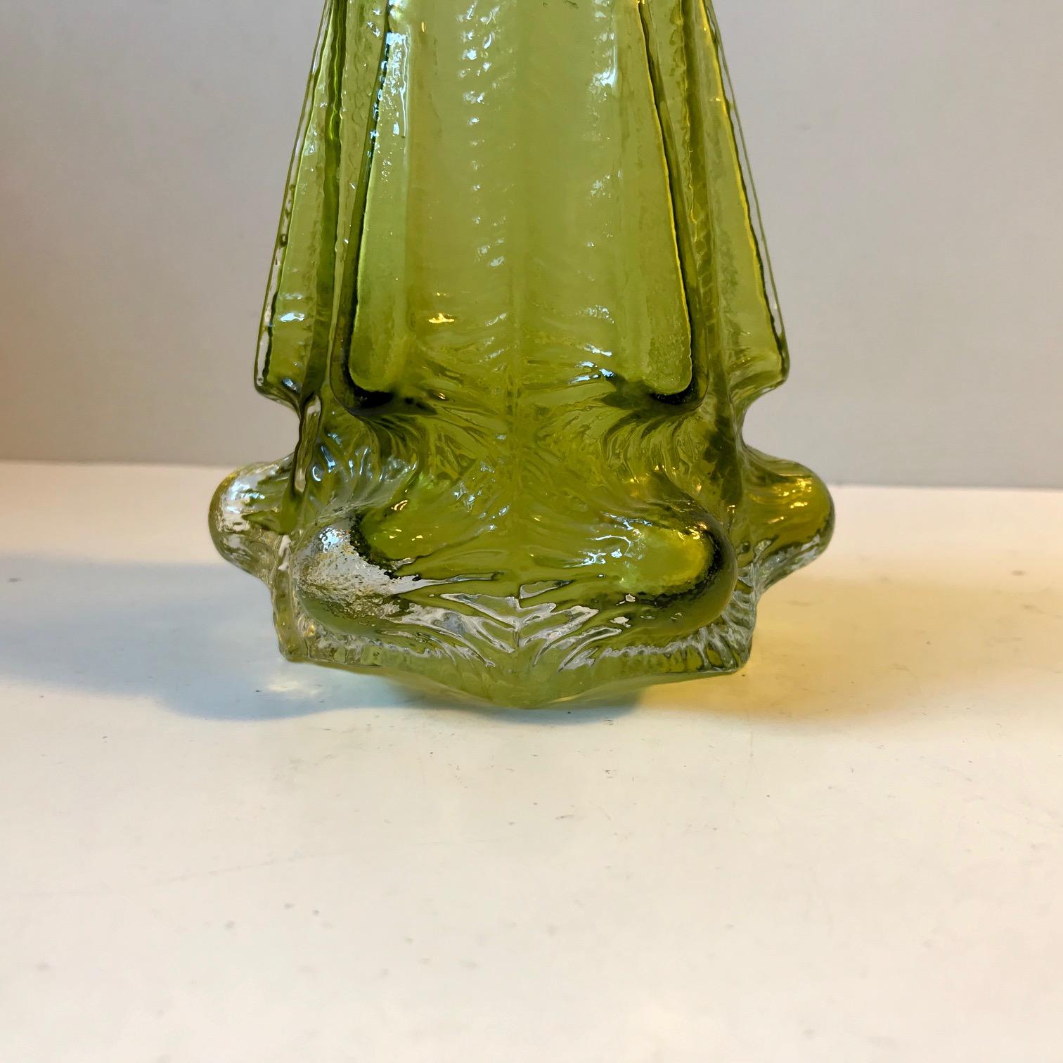 A rare cased green glass bud vase. Designed by Geoffrey Baxter and manufactured by Whitefriars in the UK during the 1970s.