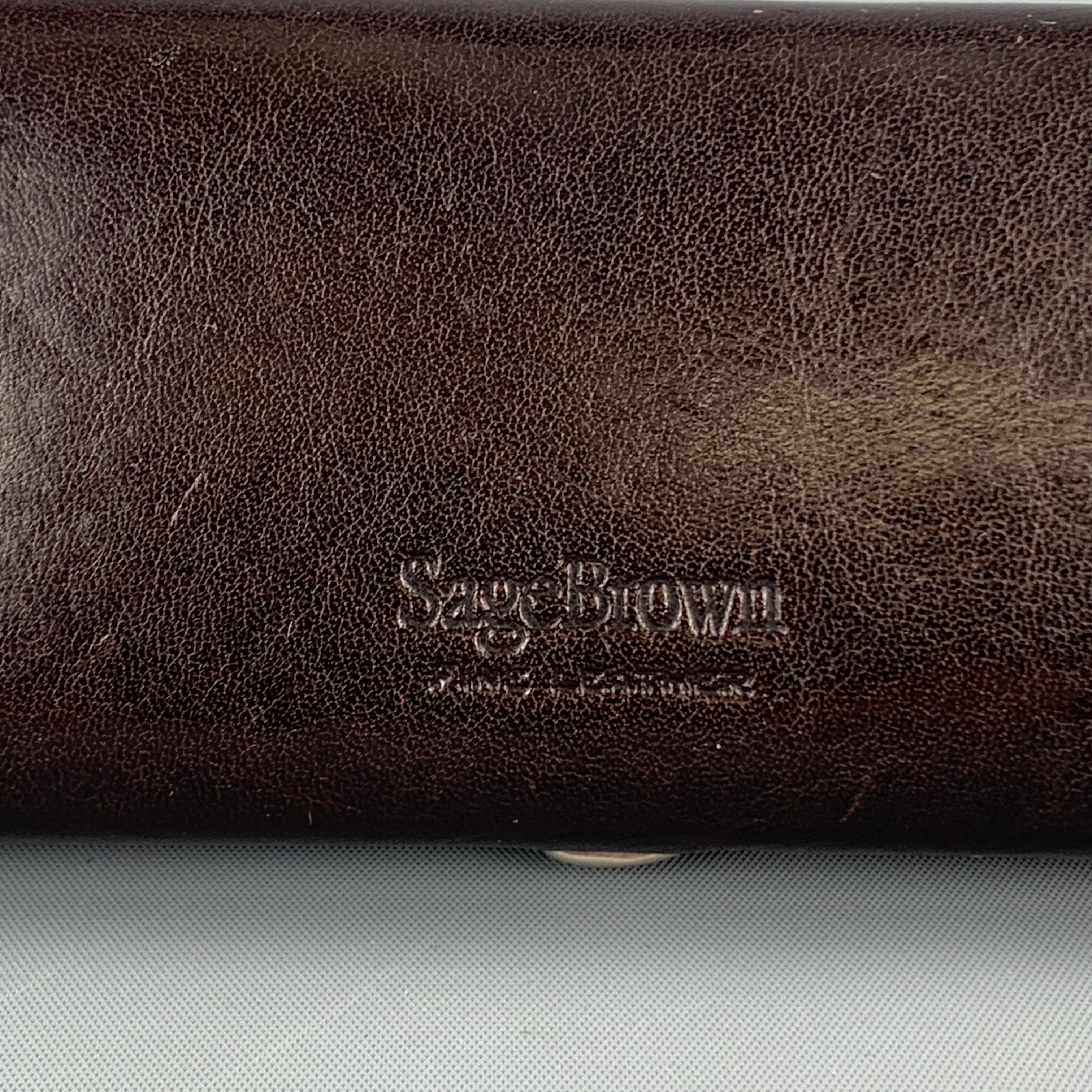 SAGEBROWN sunglasses case comes in deep brown leather with stamped logo, hing closure, and grey interior. 

Good Pre-Owned Condition.

Size: 6.25 x 2.5 in.
Width: 0.75 in.