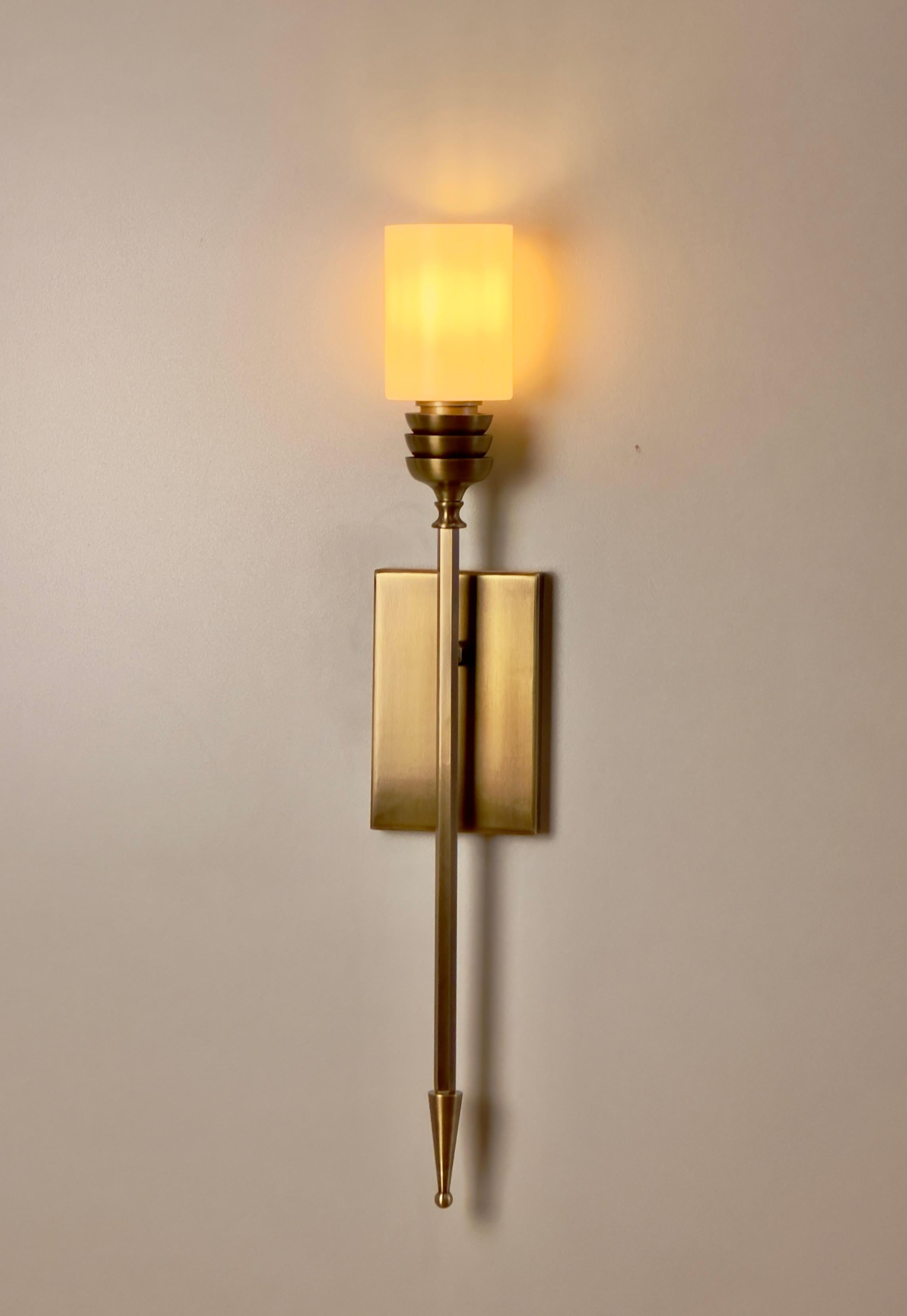 SAGOVIA brass wall lighting is a stunning representation of Mid-Century Modern style, meticulously crafted to add a touch of elegance and sophistication to any space. This exceptional wall sconce is expertly designed, featuring a cylindrical glass