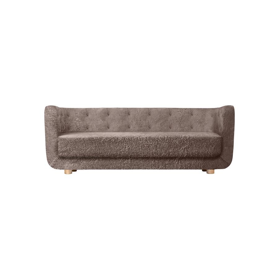 Sahara sheepskin and natural oak Vilhelm sofa by Lassen
Dimensions: W 217 x D 88 x H 80 cm 
Materials: Sheepskin, Oak.

Vilhelm is a beautiful padded 3-seater sofa designed by Flemming Lassen in 1935. A sofa must be able to function in several
