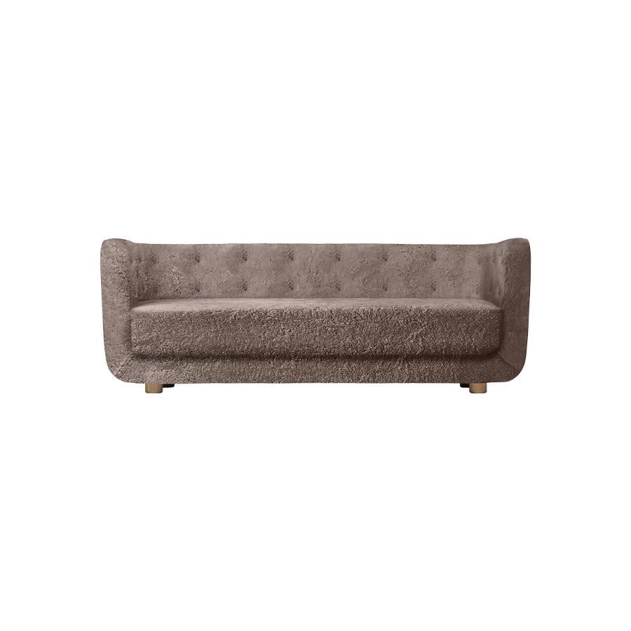 Sahara Sheepskin and Smoked Oak Vilhelm sofa by Lassen
Dimensions: W 217 x D 88 x H 80 cm 
Materials: Sheepskin, Oak.

Vilhelm is a beautiful padded three-seater sofa designed by Flemming Lassen in 1935. A sofa must be able to function in