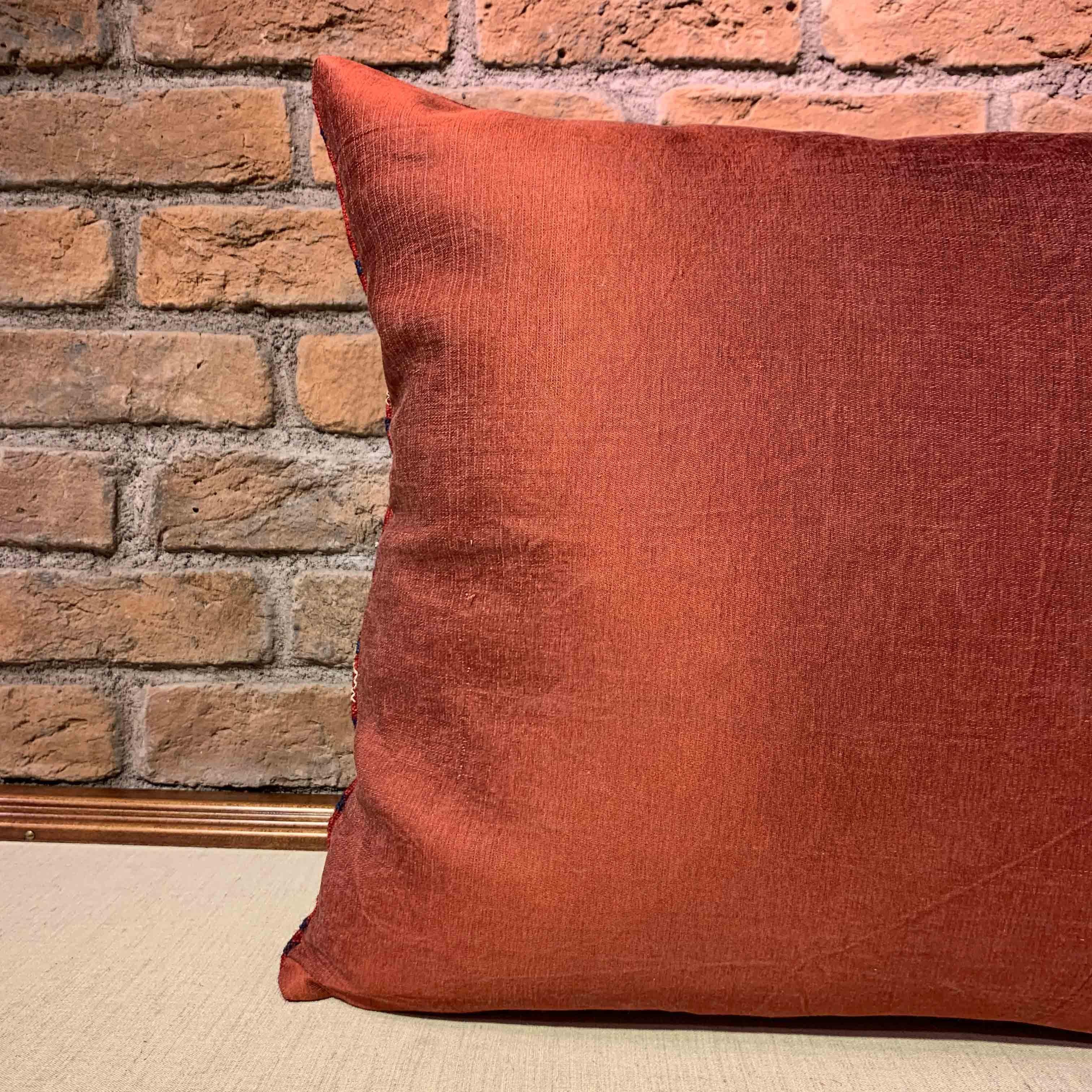 Tessuto in lana rosso intenso con motivi geometrici a rombi, questo copricuscino quadrato si ispira alle ricche tradizioni tessili tribali dell'Anatolia centrale. Il tessuto anteriore, risalente agli inizi del XX secolo, presenta sottili variazioni