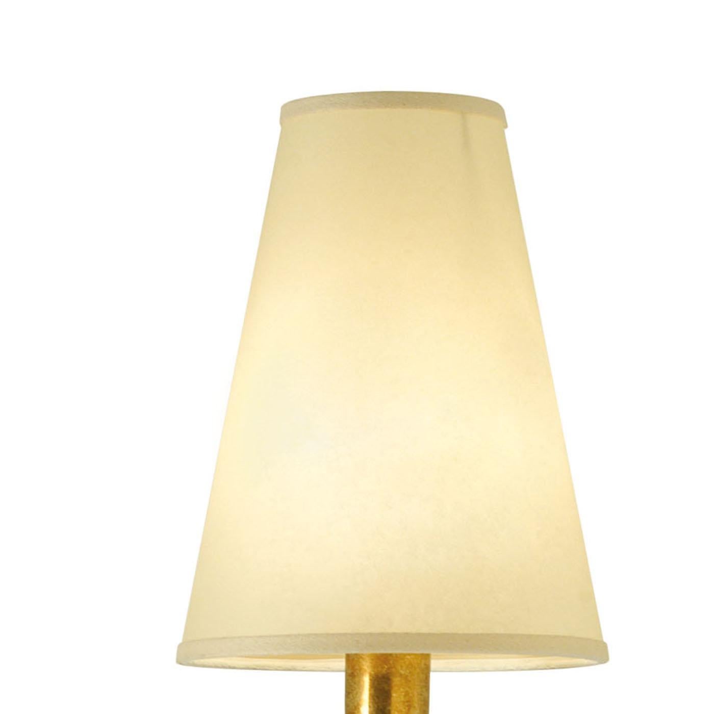 This elegant sconce features warm colors and classic charm. It is comprised of a round brass structure attached to the wall that supports a metal shaft finished with a characteristic rust color. The brass is present also here in round and