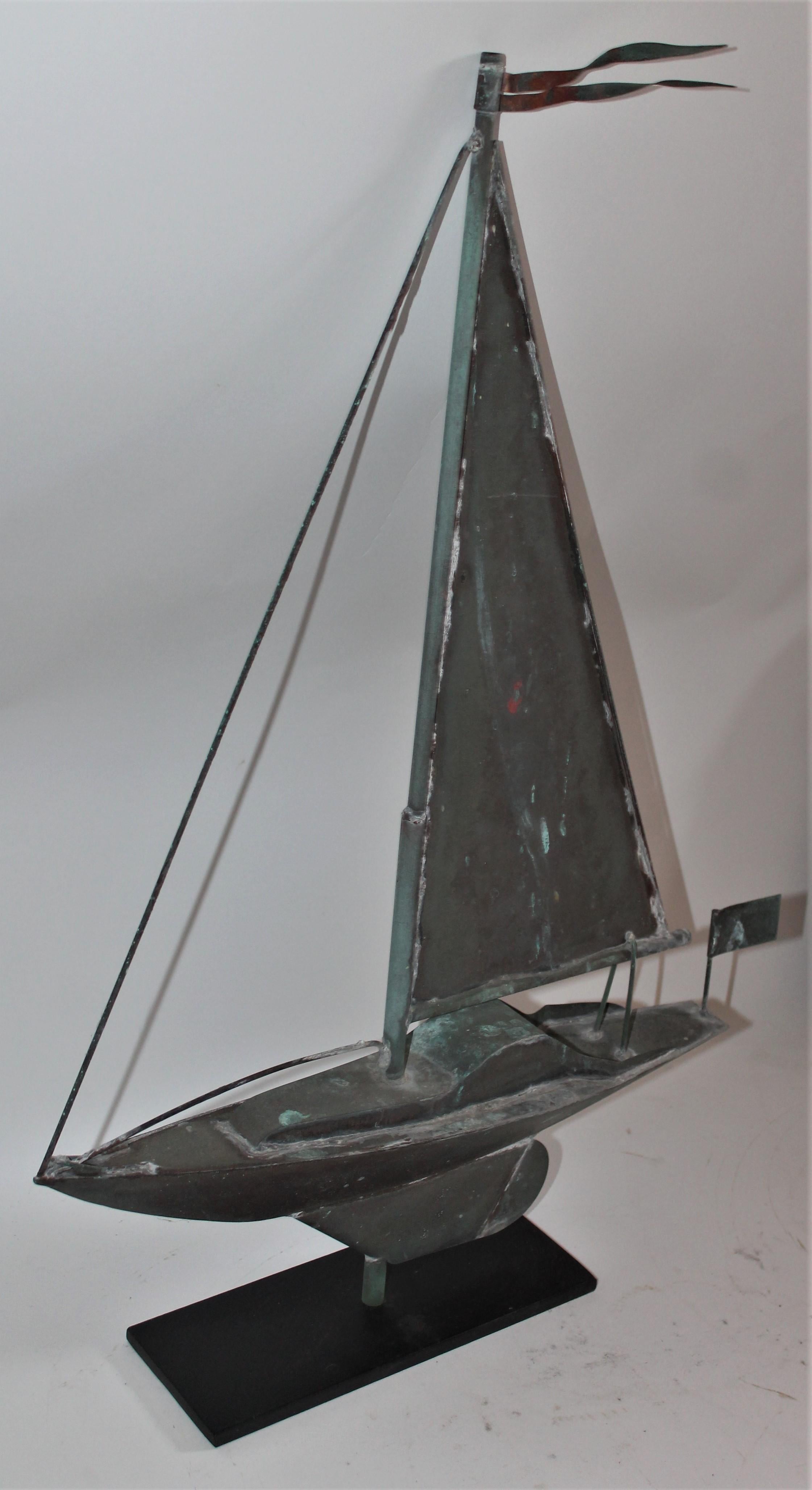 This is a copper mini- sail boat weather vane is on a cast iron mount and in good condition. This vane is probably from a boat house due to its size.