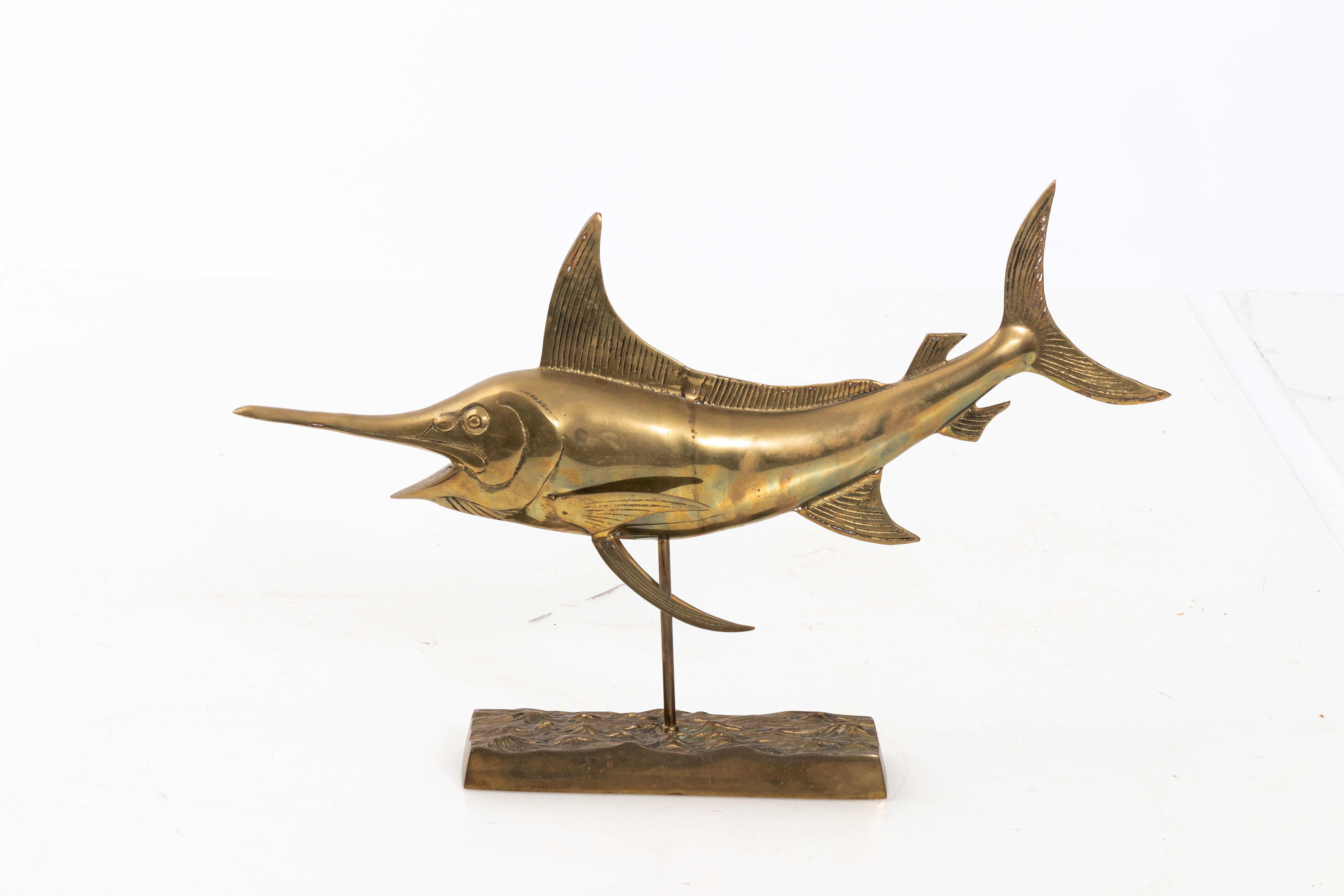 Large scale brass full body sail fish sculpture mounted on a rectangular brass base.