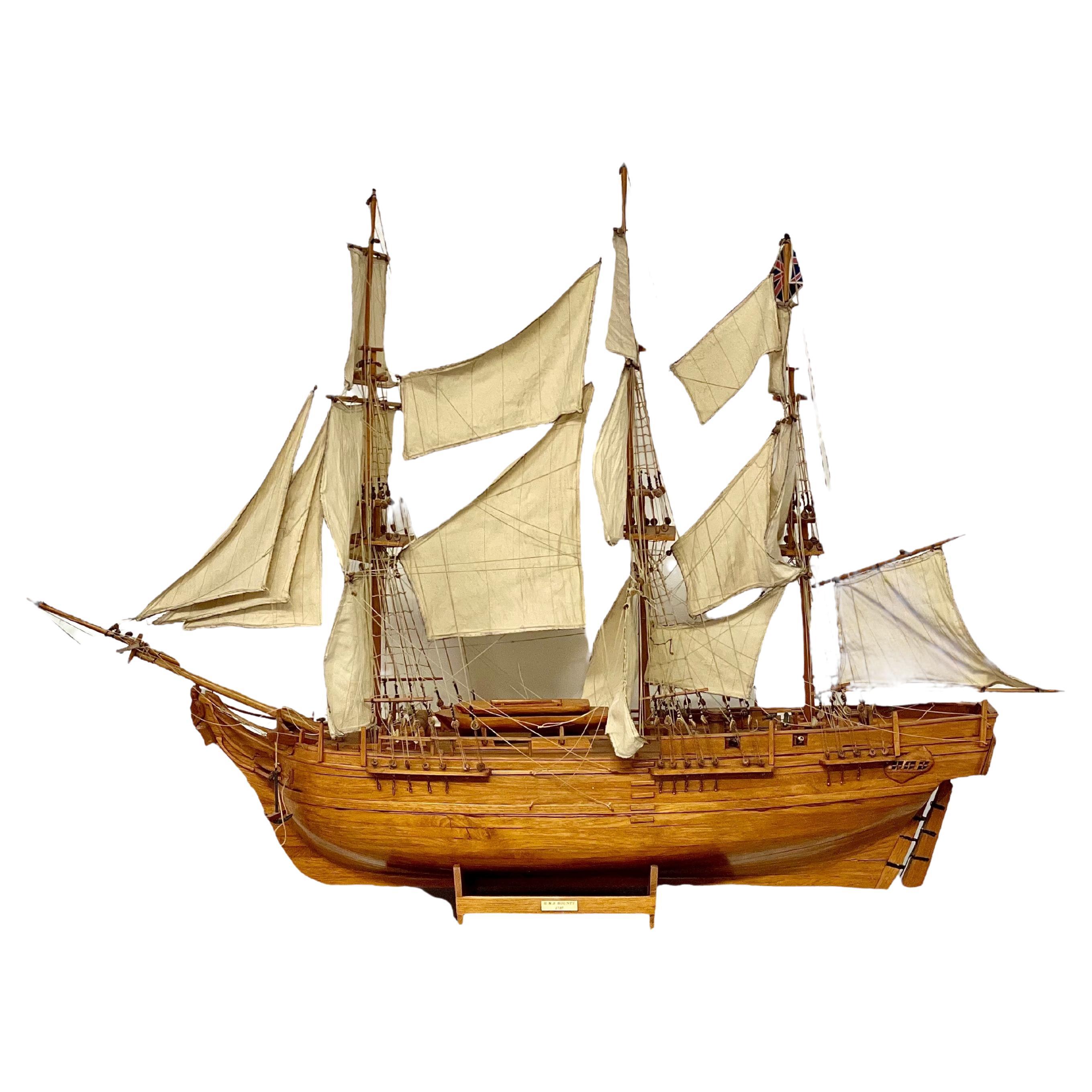 This stunning handcrafted model represents the H.M.S. Bounty, a historic ship famously launched in 1787. The replica is meticulously crafted from walnut, showcasing incredible attention to detail and the artistry of traditional shipbuilding