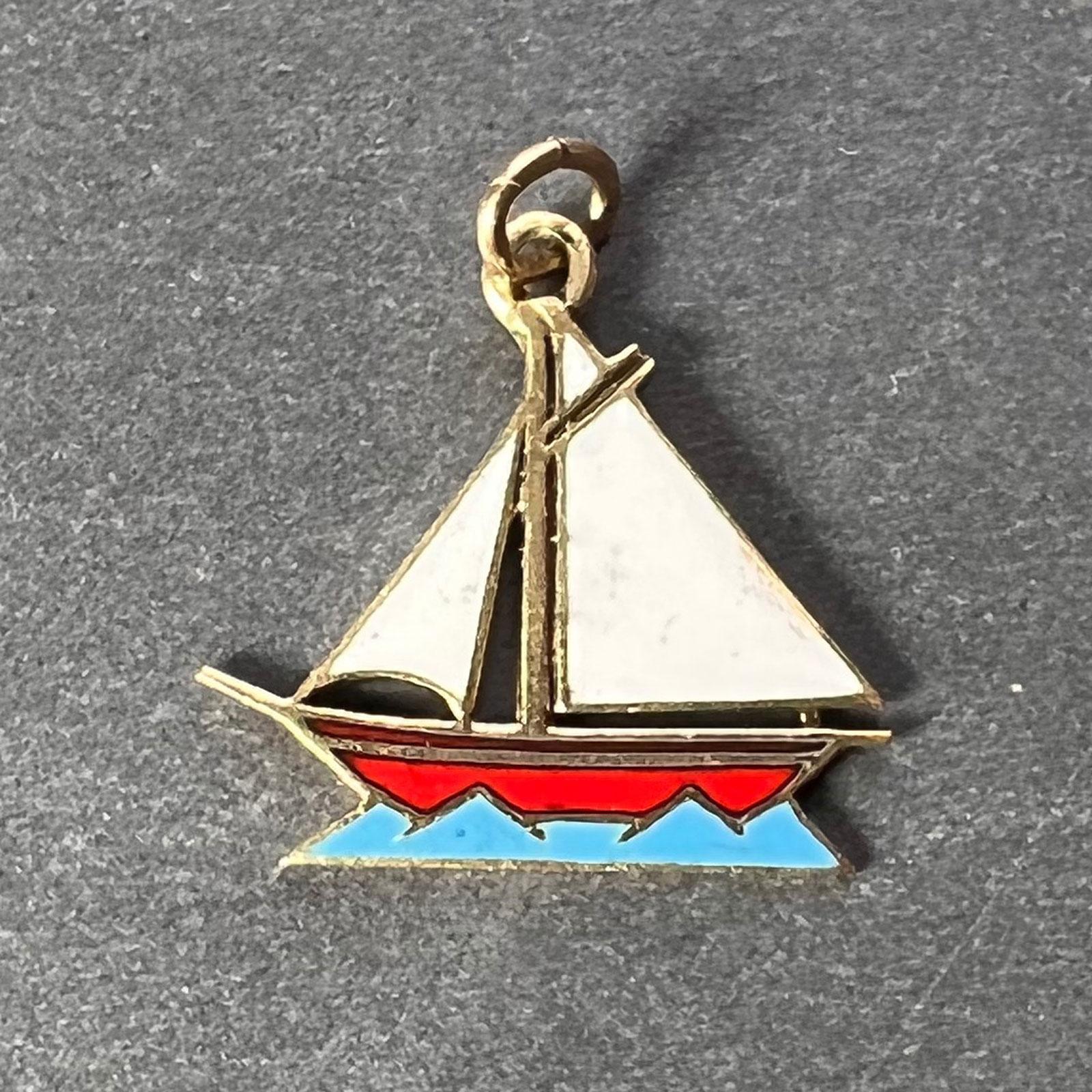 A 14 karat (14K) yellow gold charm pendant designed as a sailing yacht with white enamel sails, red enamel hull and blue enamel sea. Unmarked but tested for 14 karat gold.

Dimensions: 1.5 x 1.6 x 0.1 cm (not including jump ring)
Weight: 0.90 grams 
