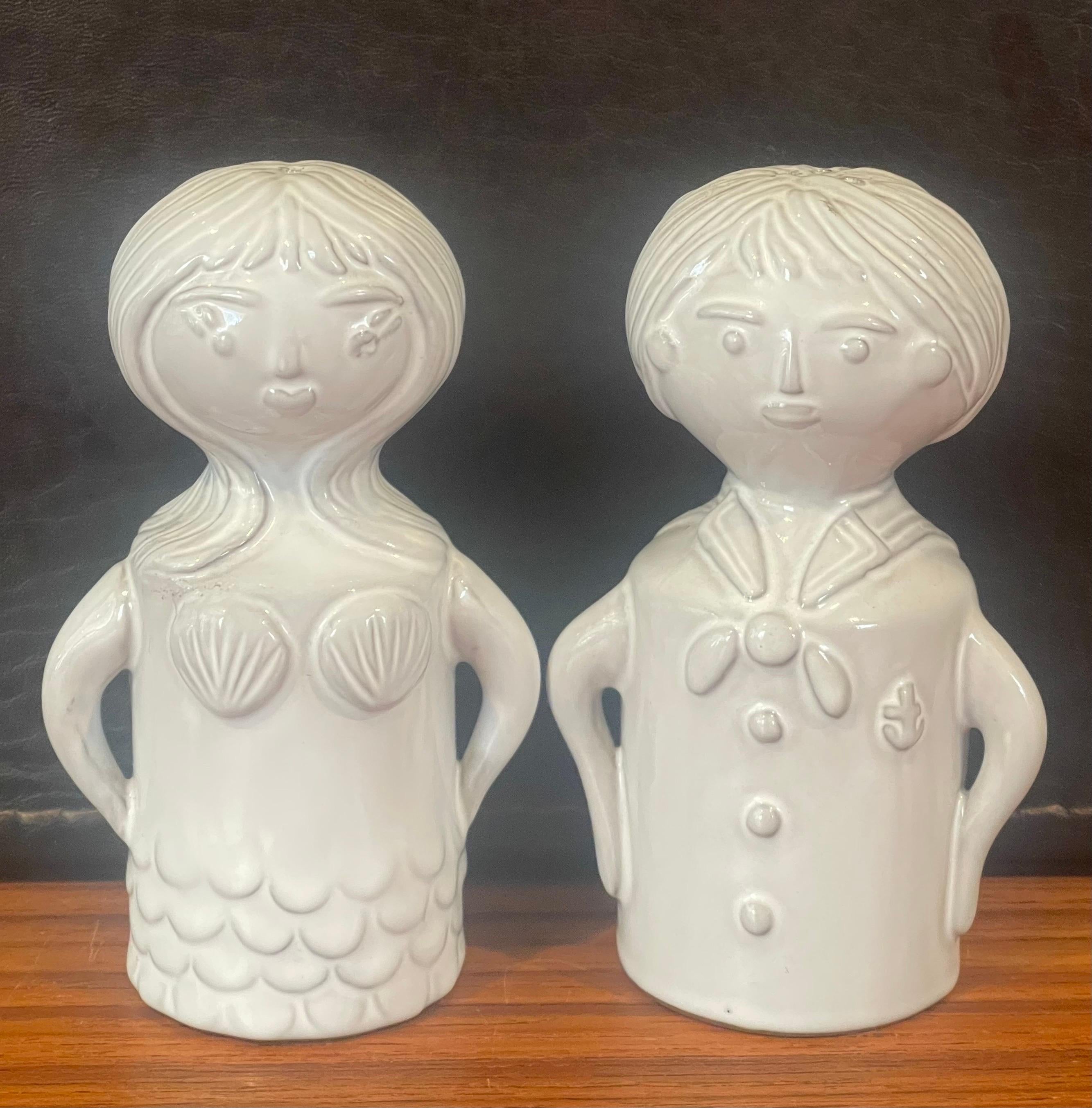 Whimsical pair of sailor and siren ceramic salt and pepper shakers by Jonathan Adler, circa 2000s.  The set is in very good condition with no chips or cracks and measures 2.5