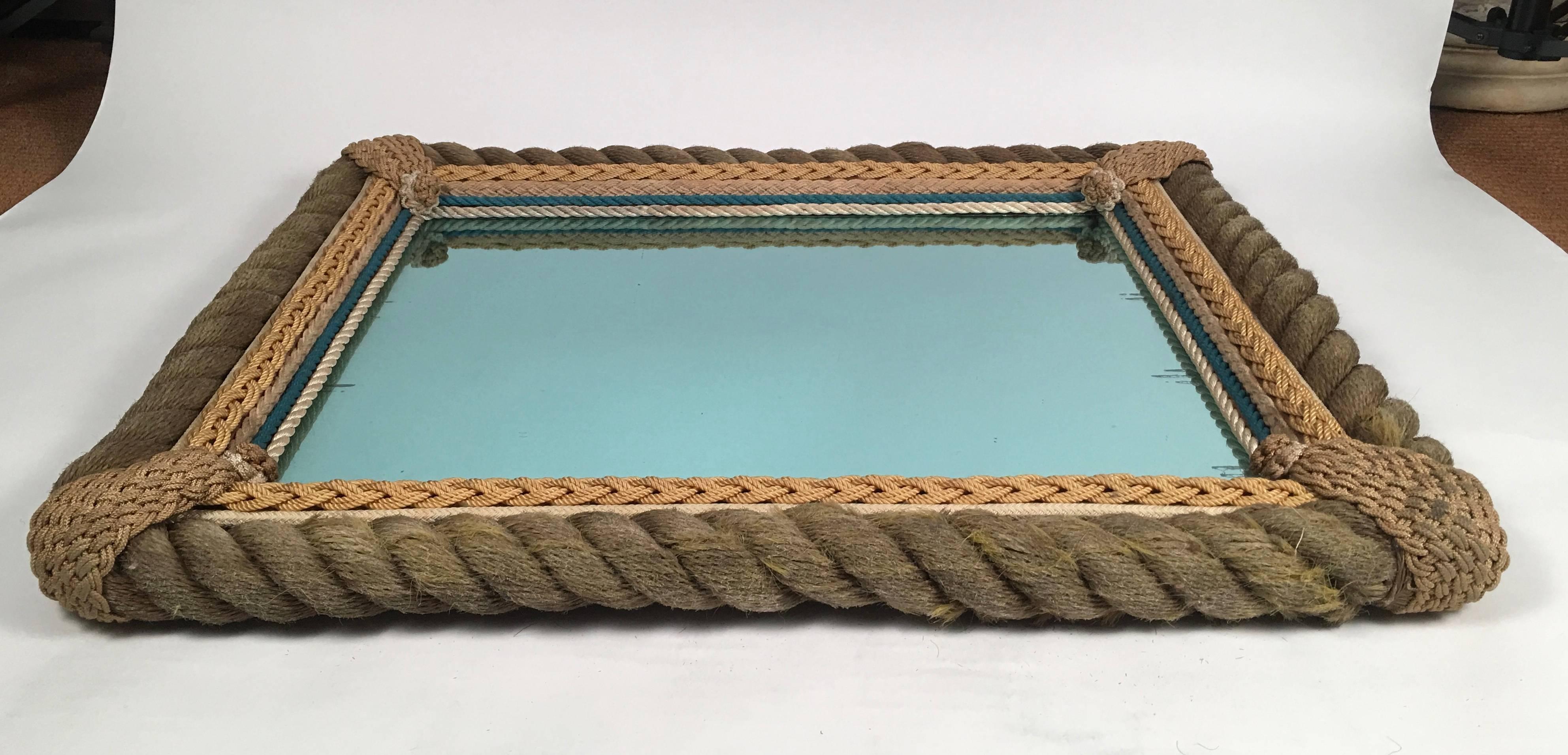 A beautifully crafted sailor made, nautical ropework frame, the thick coiled rope decorated with intricate knot work at each corner over a border of intricate knotted and braided rope which is lined with parallel lines of both blue and white rope.