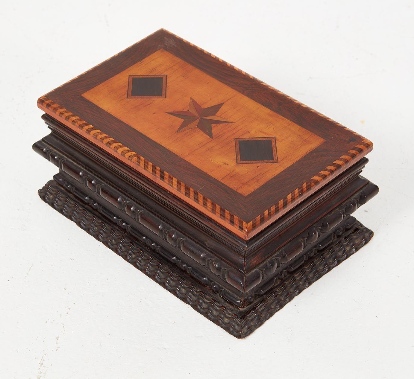 A sailor's ditty box for holding a sailor's valuables (mending needles, thread, pipe tobacco, razor, mementos, etc.) having a mirrored and gilt framed interior lid, with pull-out compartment dividers in two layers below.  Inlaid top of six-point