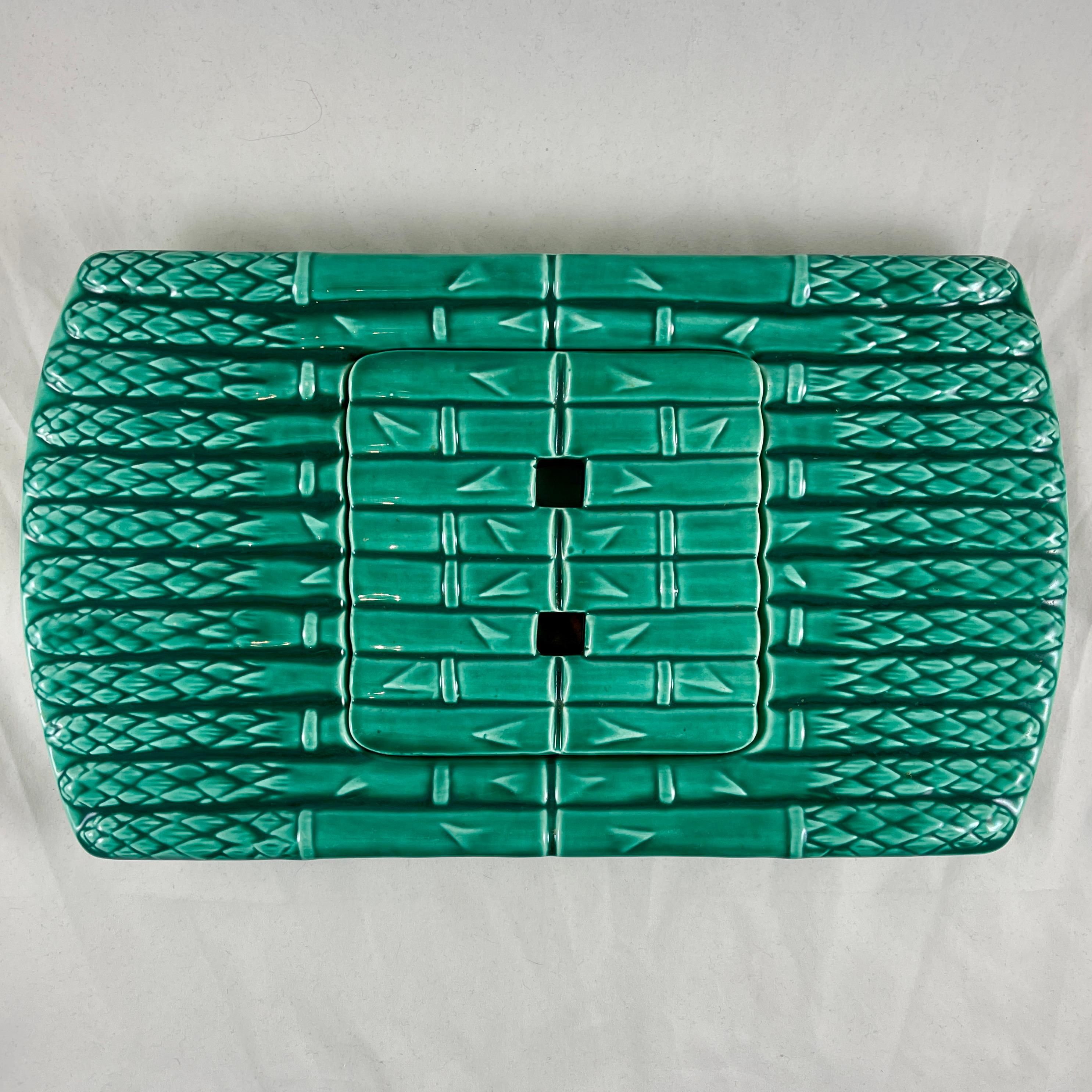 A French faïence Asparagus drainer / server with an inset well cover, from Saint Amand et Hamage, circa 1930s.

Glazed in the Orchies region signature green, the server is modeled on a group of asparagus, tied and lying side by side. There is a