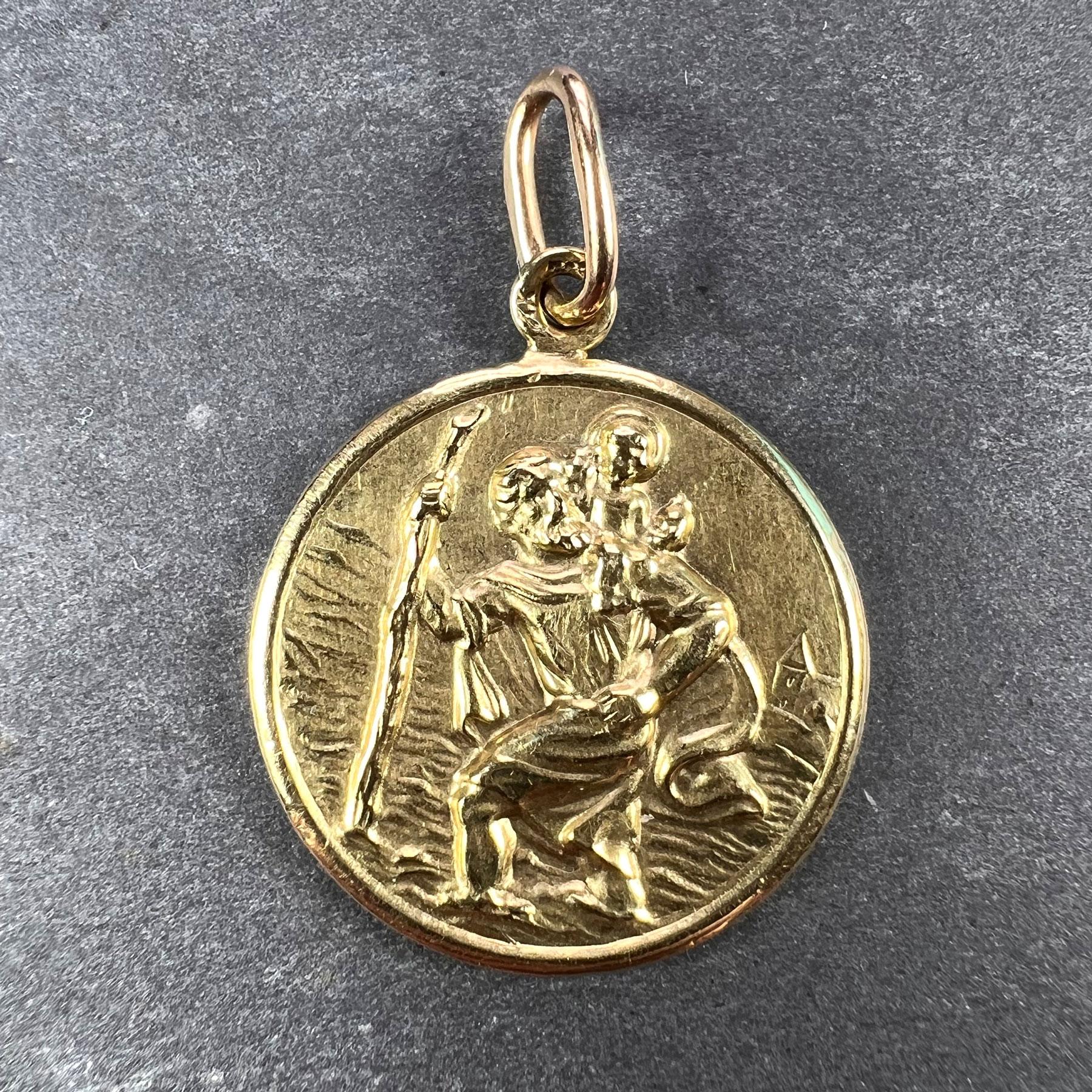 A 14 karat (14K) yellow gold charm pendant designed as a medal depicting Saint Christopher carrying the infant Christ over a river. Engraved ‘Mummy and Daddy’ to the reverse. Stamped 585 for 14 karat gold.

Dimensions: 2.3 x 2 x 0.2 cm (not