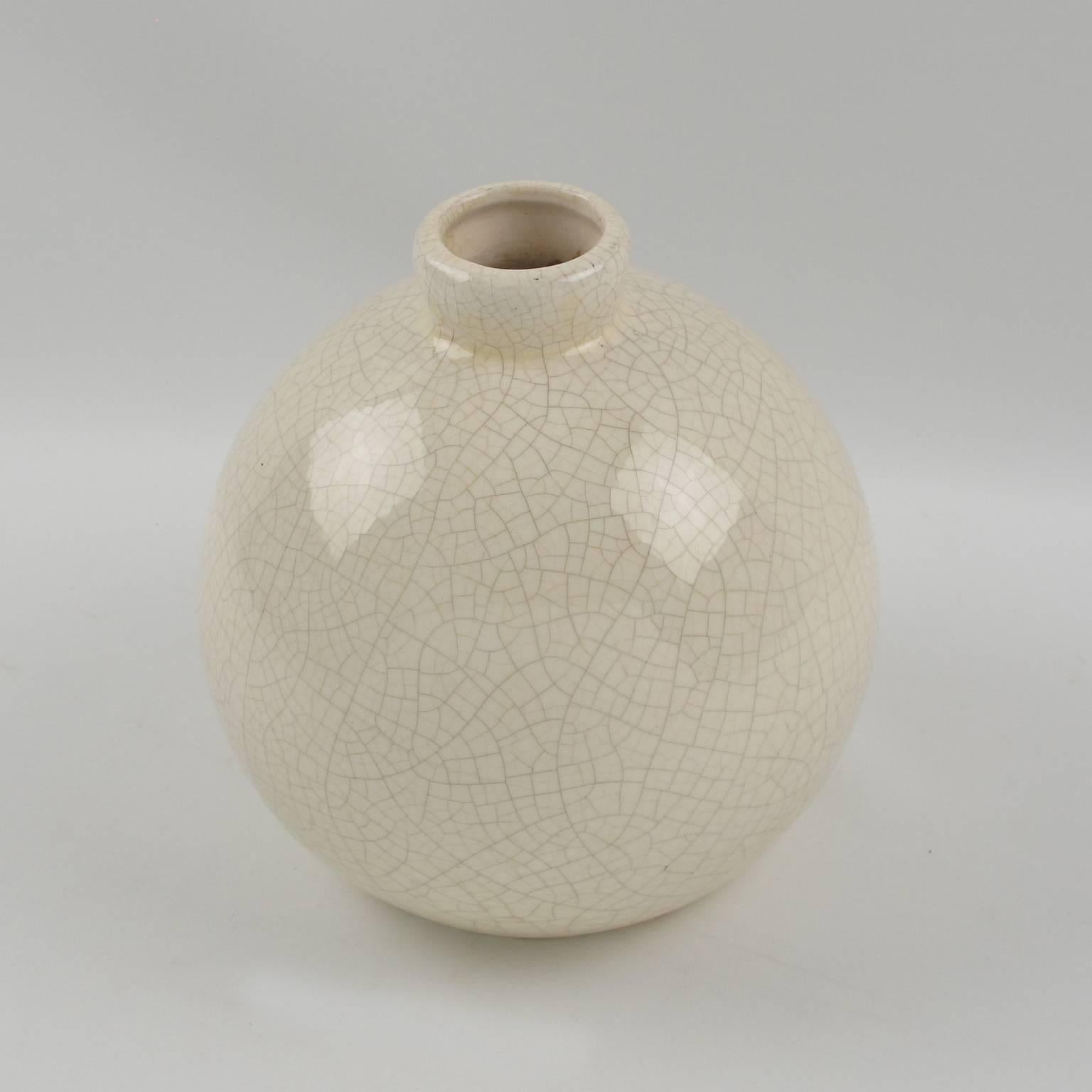 Art Deco vase by Saint-Clement, France. Ceramic vase with off-white crackle glaze finish. Features a round streamline design with tiny collar opening. Engraved model number underside. The crackle clear glaze was a popular technique for animal and