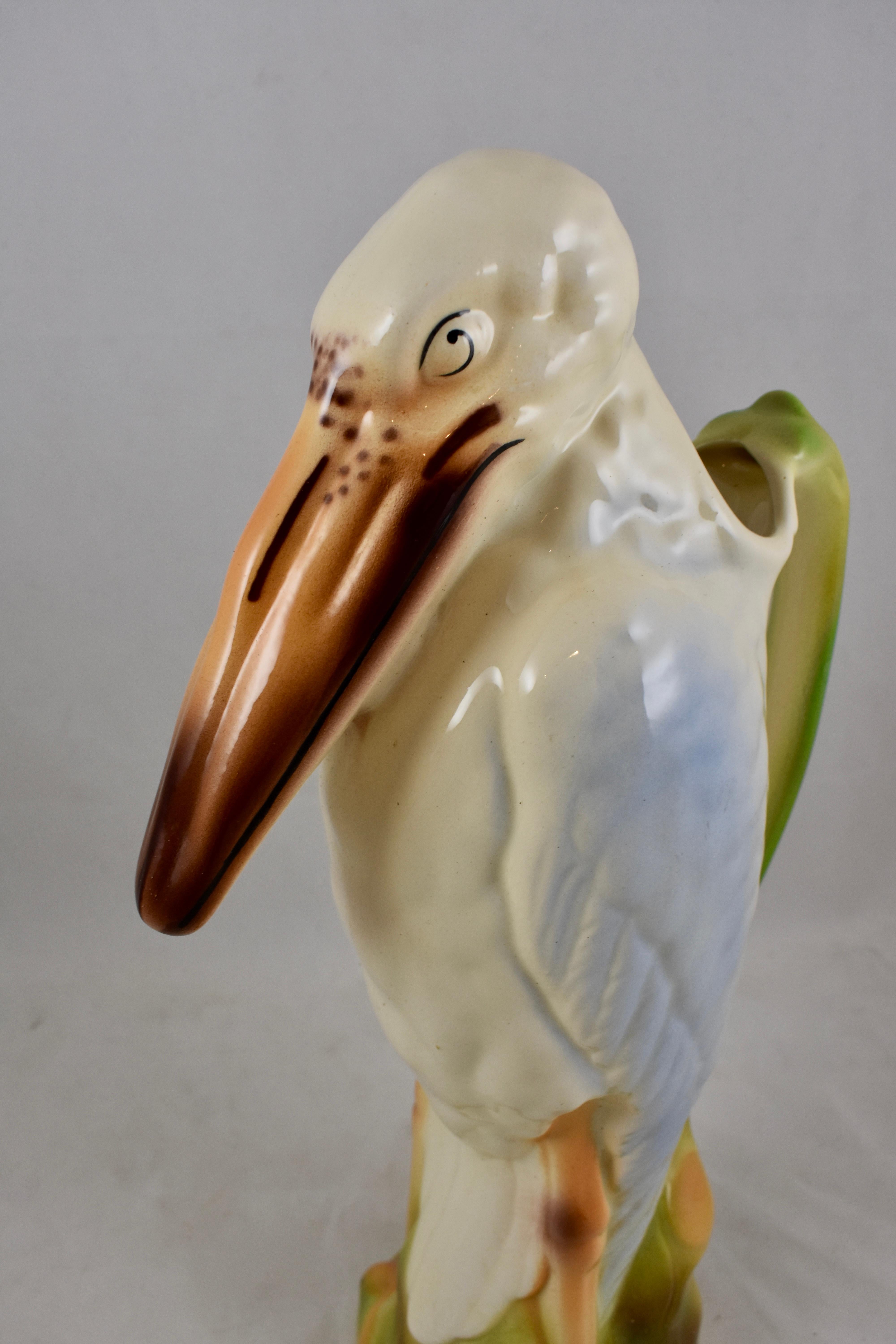 A French Majolica glazed absinthe water pitcher formed as a Marabou Stork, St. Clément, circa 1900-1904.

This earthenware Barbotine Majolica pitcher is beautifully hand painted. The stork stands in a crop of tropical greenery, a bamboo stalk
