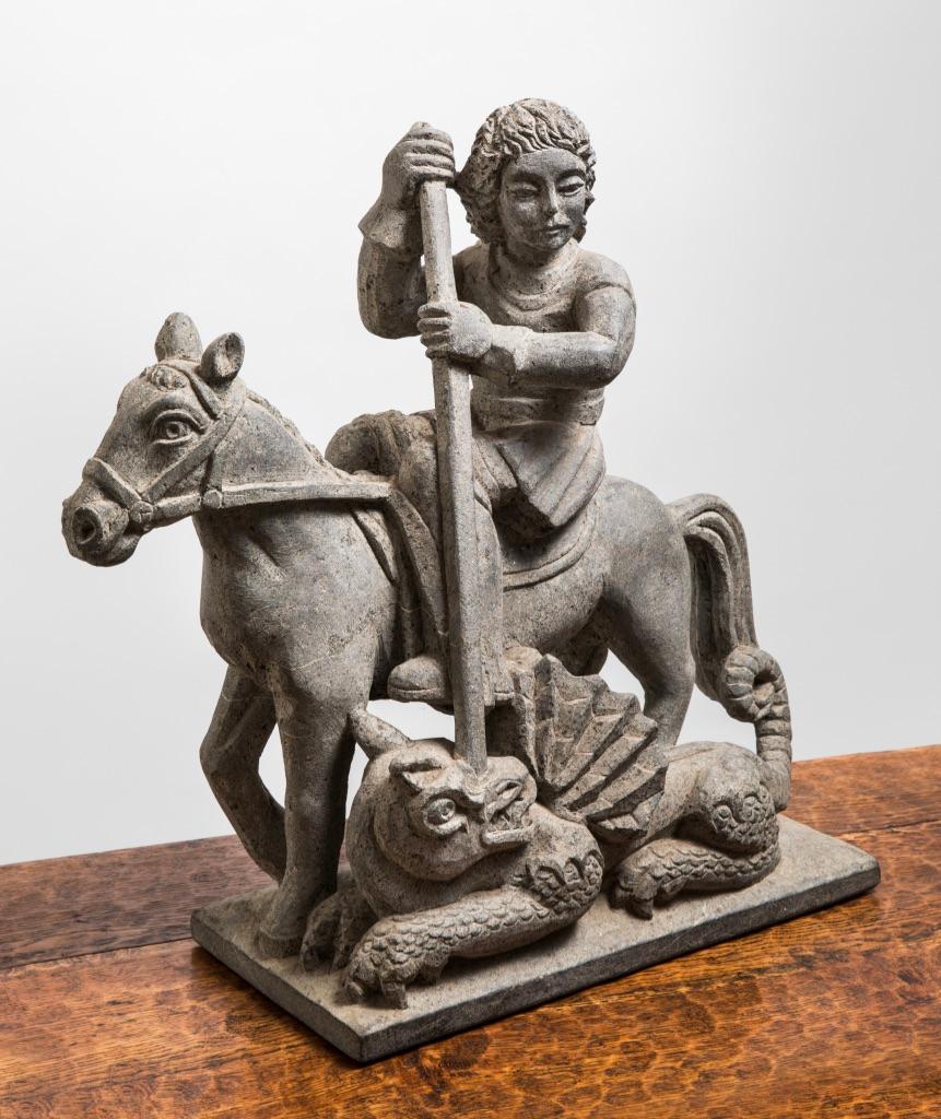 Diese Skulptur des bretonischen Bildhauers Raymond Vaillant stellt den berühmten Heiligen Georg dar, der den Drachen tötet und damit eine böse Macht vernichtet, die von Menschenopfern lebte. Hier sehen wir, wie der Reiter die Bestie hinrichtet und
