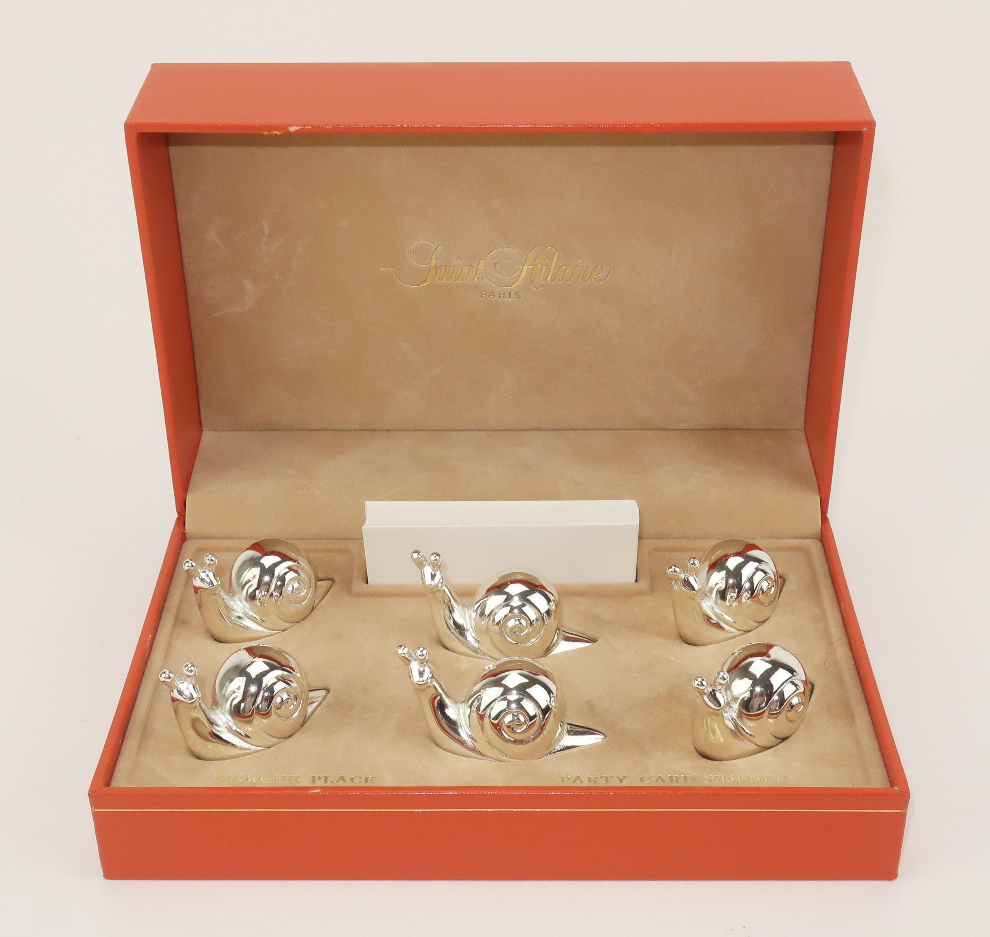 Set of 6 silverplate snail place card holders in the original box by Saint Hilaire of Paris. The whimsical snails have a low maintenance varnished finish and offer a hidden card slot at the base. The set is accompanied by a stack of white cards. A
