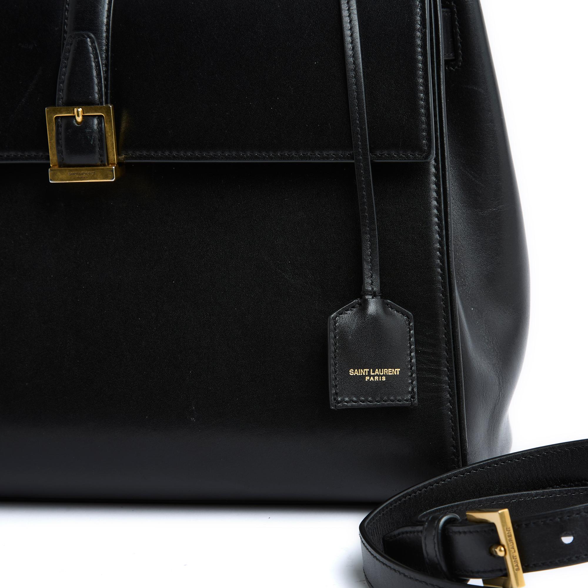 Medium Saint Laurent Le Fermoir model bag in black leather, black leather interior with a zipped pocket closed by a large flap and its famous tilting clasp, 1 last large patch pocket on the back, 1 handle for carrying the hand and 1 removable and