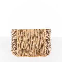 Pulsera cuadrada tipo manguito de SAINT LAURENT, en tono dorado envejecido, con textura de corteza de árbol