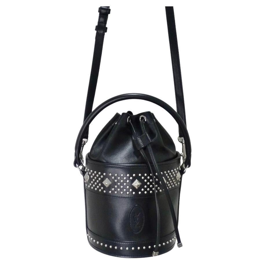 The perfect every day bucket bag has arrived! Your go-to versatile handbag is elevated with an edgy flare utilizing silver studs contrasting a black calfskin leather. Inspired by the architecture of Marrakesh, this handbag features an Yves Saint