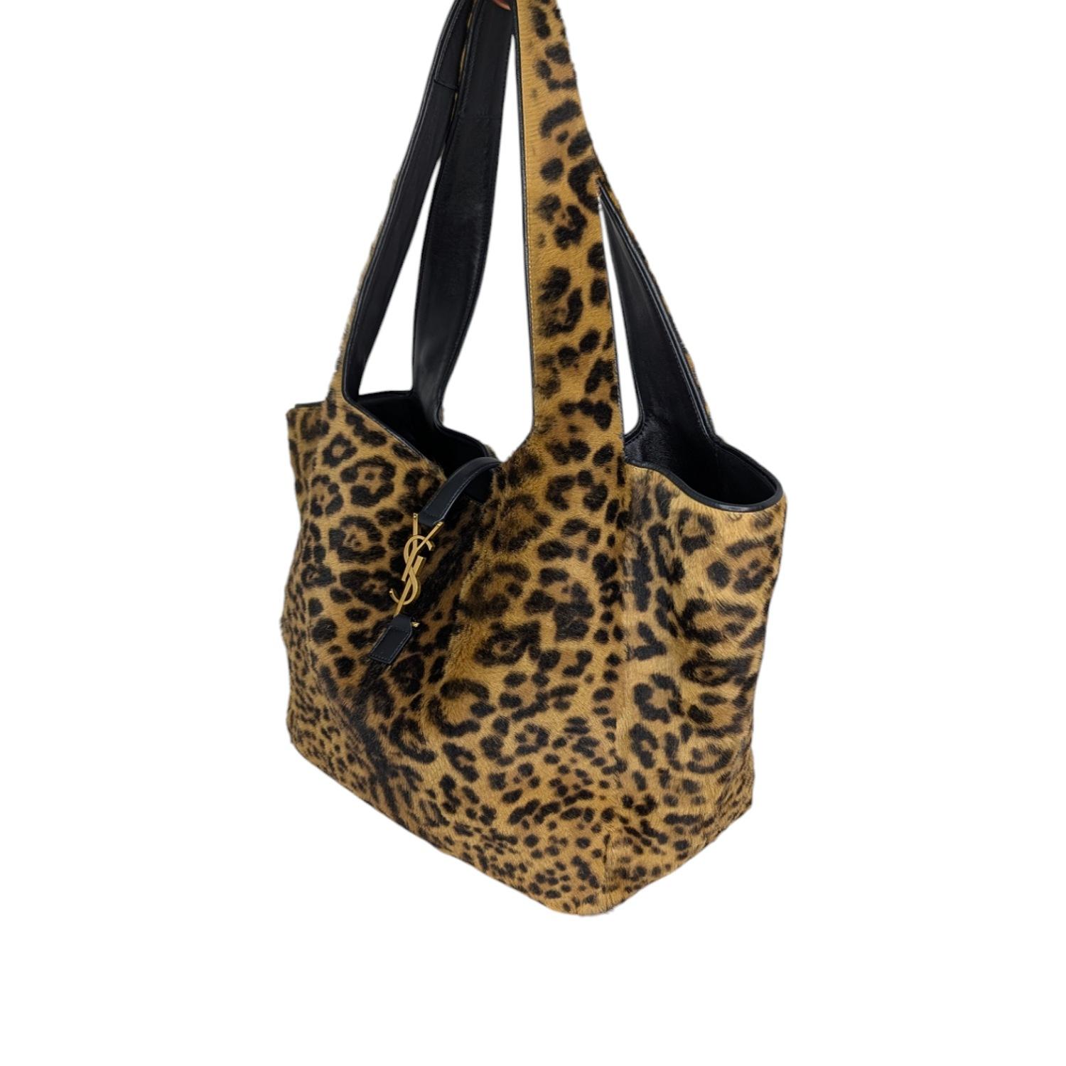 Supple tote in leopard-print pony hair and Nappa leather. Lightweight and fully lined in suede, it features shoulder straps, an open top with a center YSL logo strap, and one zip pocket on the inside. Its east/west format makes it both spacious and