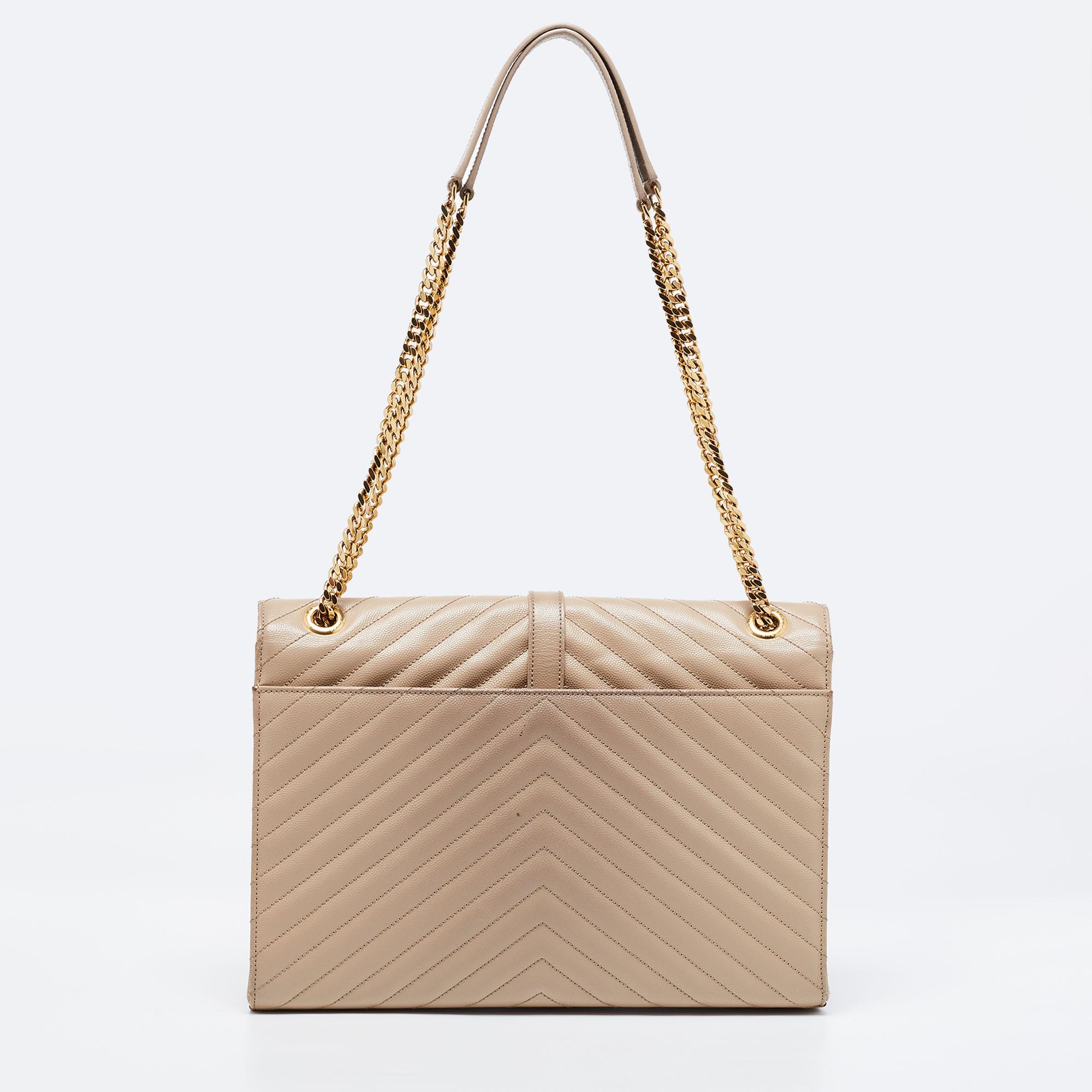Elevate your everyday looks with this reliable Envelope shoulder bag by Saint Laurent. It is crafted from leather in a beige hue. It features the YSL logo in gold-tone on the front flap, and the bag is designed fabulously. The flap opens to reveal a