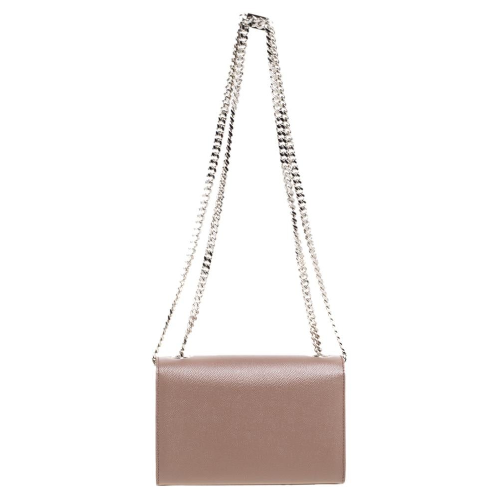 Meticulously crafted from high-end leather, this Saint Laurent Kate shoulder bag exudes just the right amount of sophistication. The beige bag features a sturdy silver-tone shoulder chain, the YSL logo on the front flap, and a fabric-lined