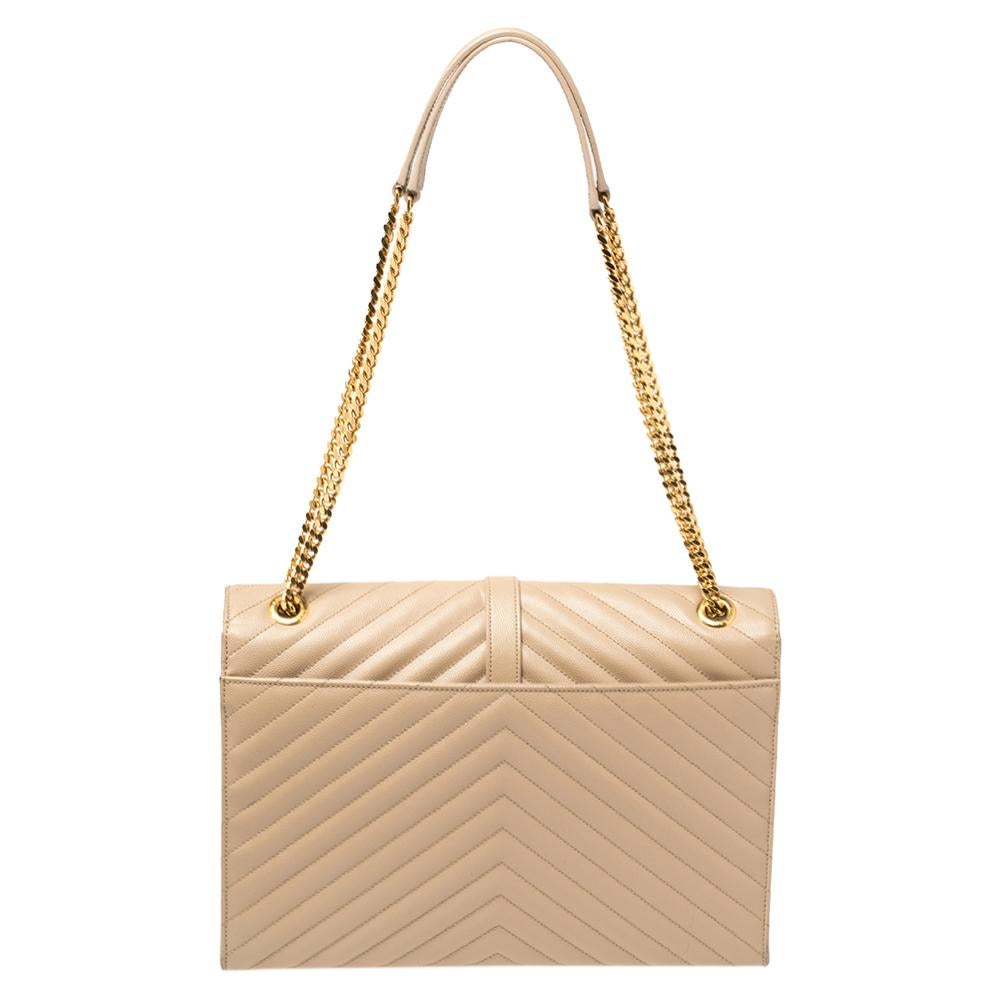 This exquisite Cassandre bag from Saint Laurent is a chic accessory representing the brand's rich aesthetics and elegant designs. Crafted from beige leather, this easy-to-carry bag has a flap style with the YSL logo in gold-tone on the front. The