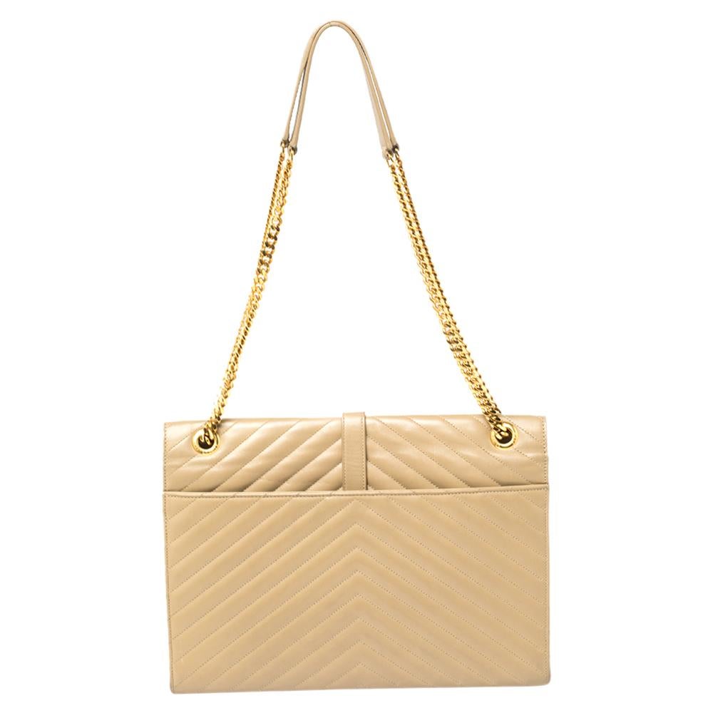 This exquisite Cassandre bag from Saint Laurent Paris is a chic accessory that represents the brand's rich aesthetics and elegant designs. Crafted from beige matelassé leather, this easy-to-carry bag has a flap style with the YSL logo in gold tone