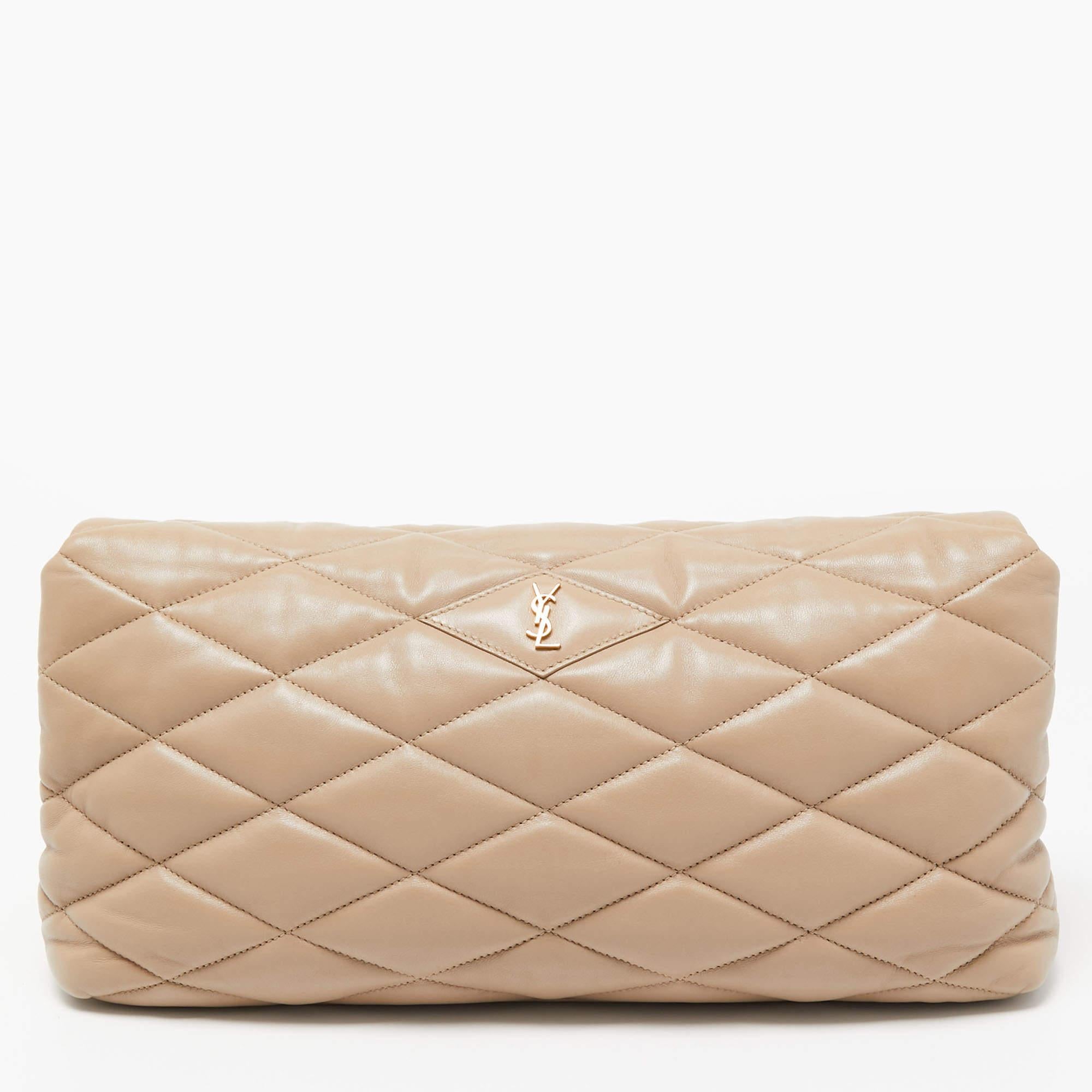 Just right for conveniently storing your valuables without weighing your look down, this Saint Laurent clutch features a puffer leather exterior with gold-tone metal fittings. Carry it in hand as a stylish evening accessory.

Includes: Original