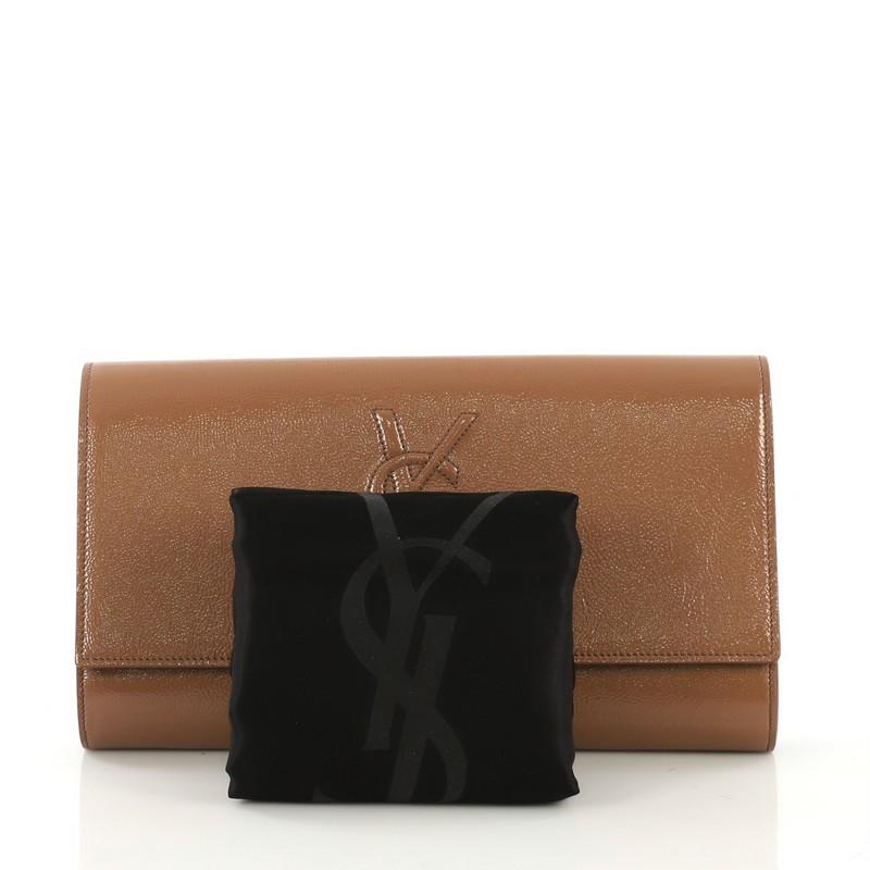 This Saint Laurent Belle de Jour Clutch Patent Small, crafted from brown patent leather, features YSL monogram logo and silver-tone hardware. Its magnetic snap closure opens to a brown satin interior with slip pocket. 

Estimated Retail Price: