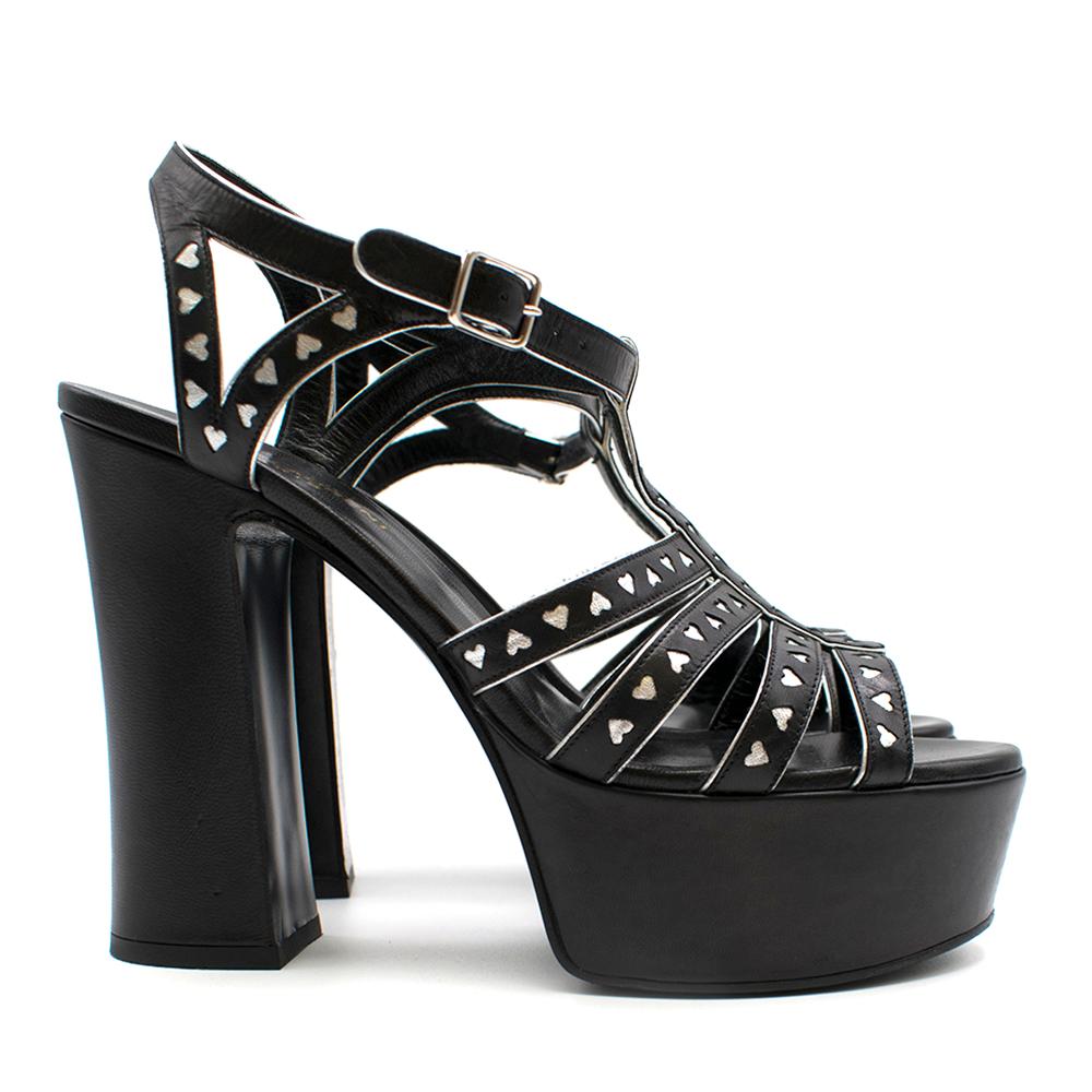 Saint Laurent Bianca Cage Heart platforms

Cage heart platforms
Strap design with silver heart detailing 
Ankle strap 
Patent leather 
Thick platform and high heel 
Open toe and open back 
Dust bag included 

Please note, these items are pre-owned