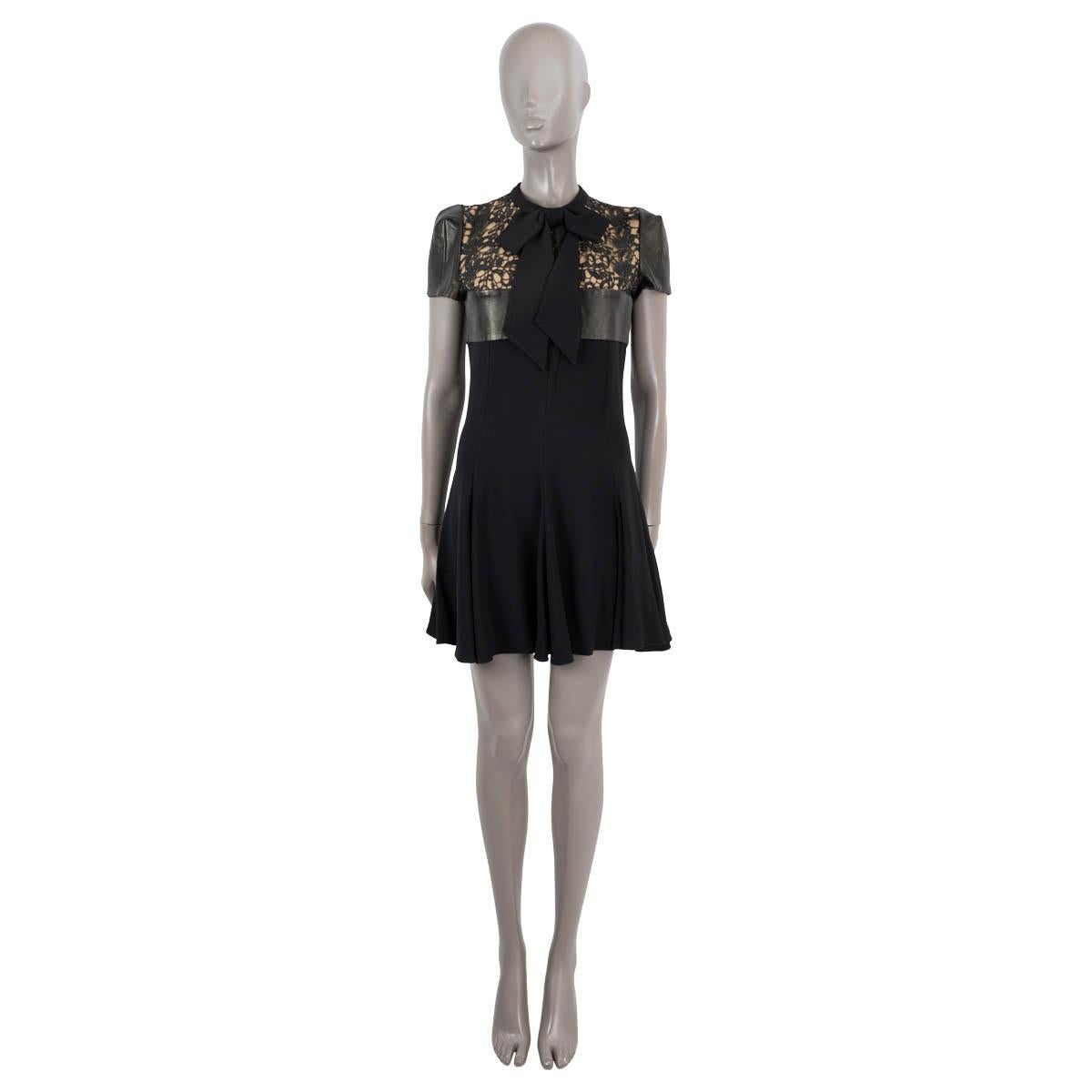 100% authentic Saint Laurent lace panelled dress in black acetate (57%) and viscose (43%). Features short leather sleeves, a pussy-bow neck and a leather waist band. Closes with a concealed zipper and a hook in the back. Has been worn and is in