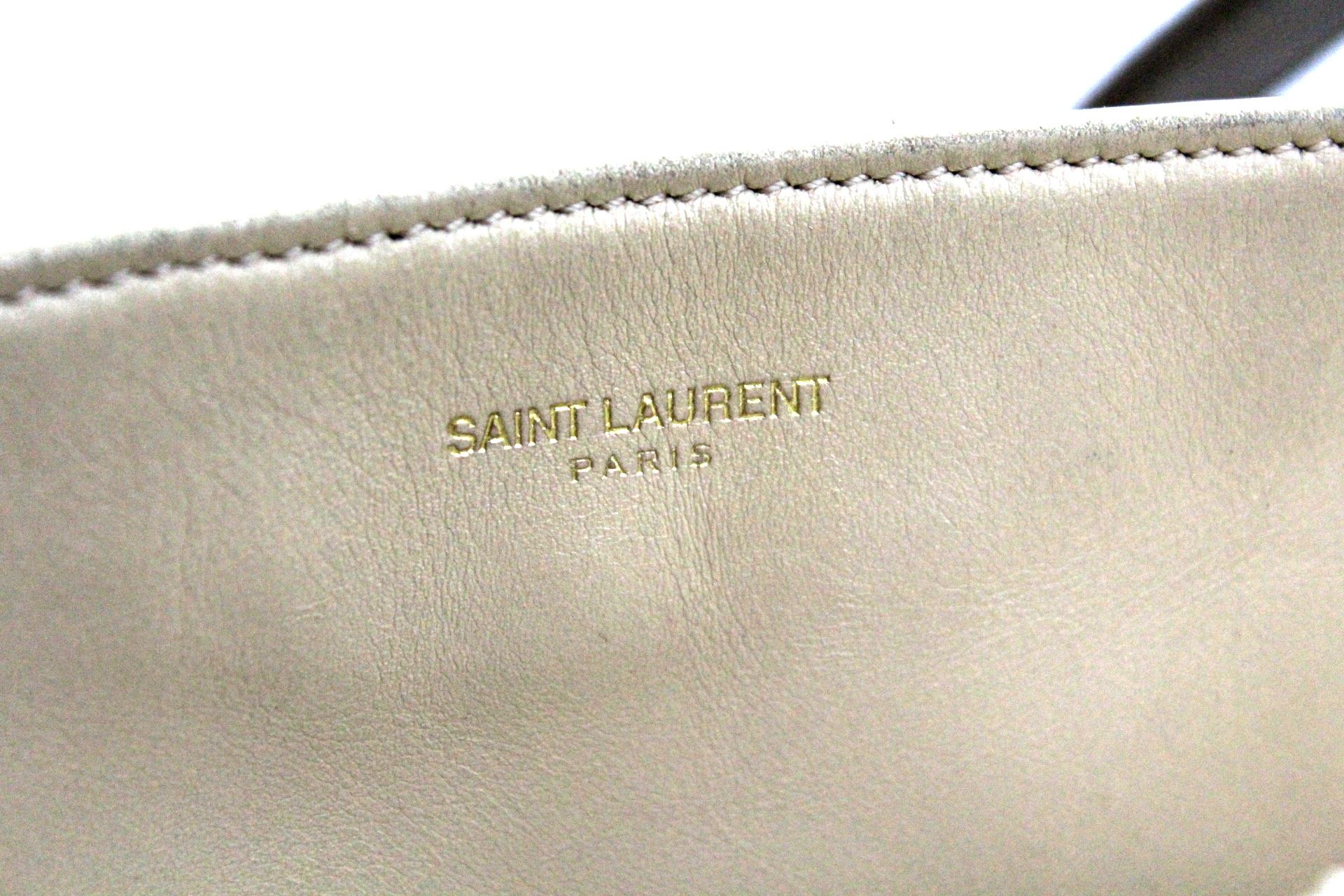 Saint Laurent Shopping Bag made of black suede and beige leather. The bag has no zip or magnetic flap closure so it is open. Internally it is equipped with a small clutch and a zippered pocket. Excellent as a daily bag to use for work or to go out.