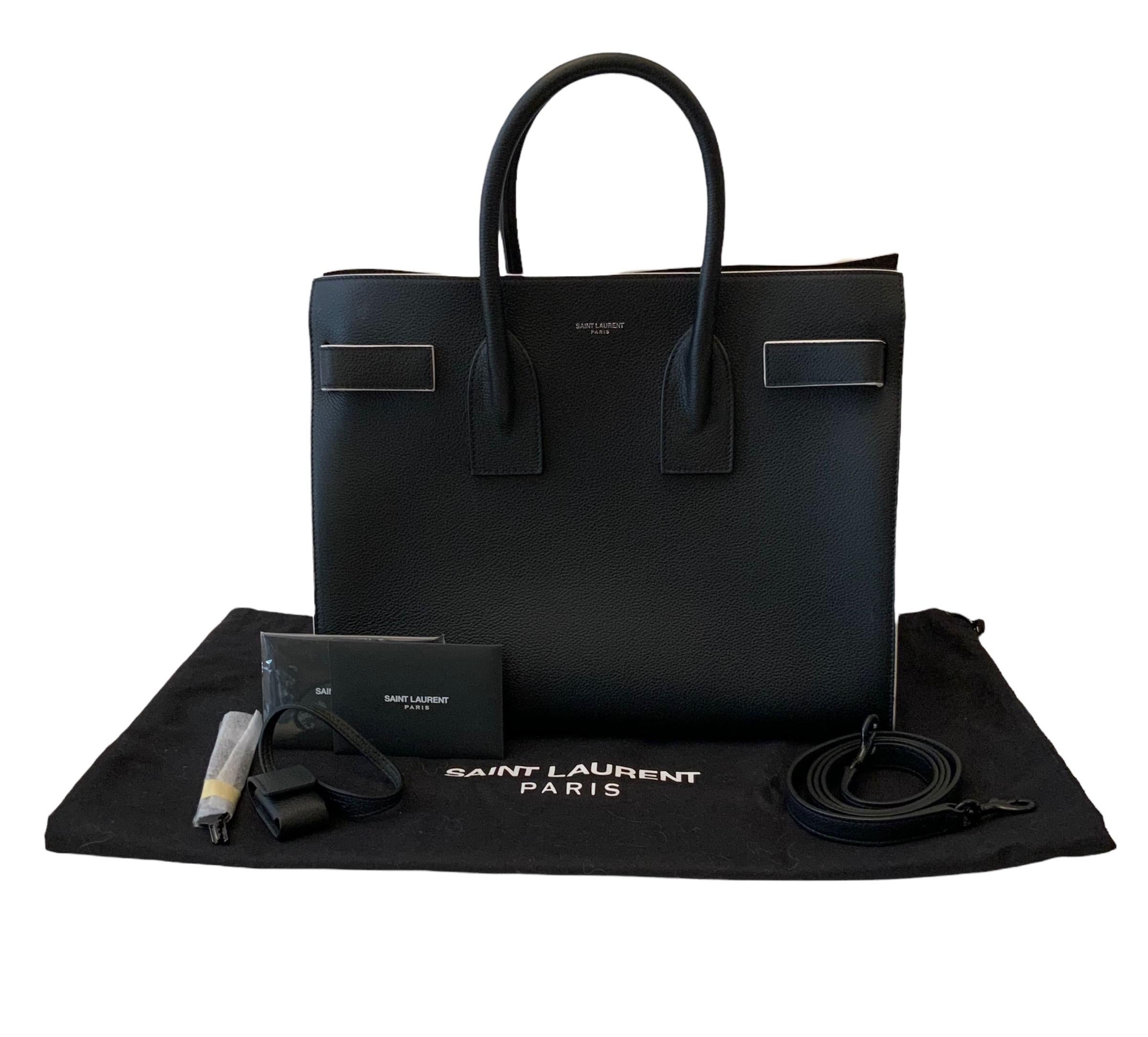 This pre-owned but in very good condition is a signature bag from the house of Saint Laurent.
It is crafted in a black smooth calfskin leather and white trim all around.
It features tubular handles, accordion sides with a compression strap with tabs
