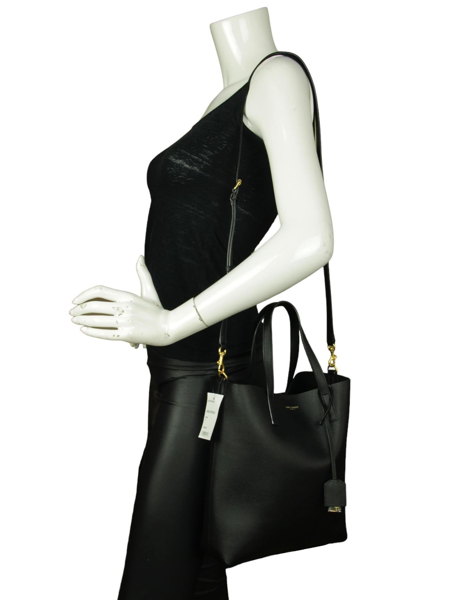 Saint Laurent Black Calfskin Toy Shopping Tote Bag w/ Detachable Shoulder Strap

Made In: Italy
Color: Black
Hardware: Goldtone
Materials: Leather
Lining: Black suede
Closure/Opening: Center magnetic closure
Exterior Pockets: None
Interior Pockets: