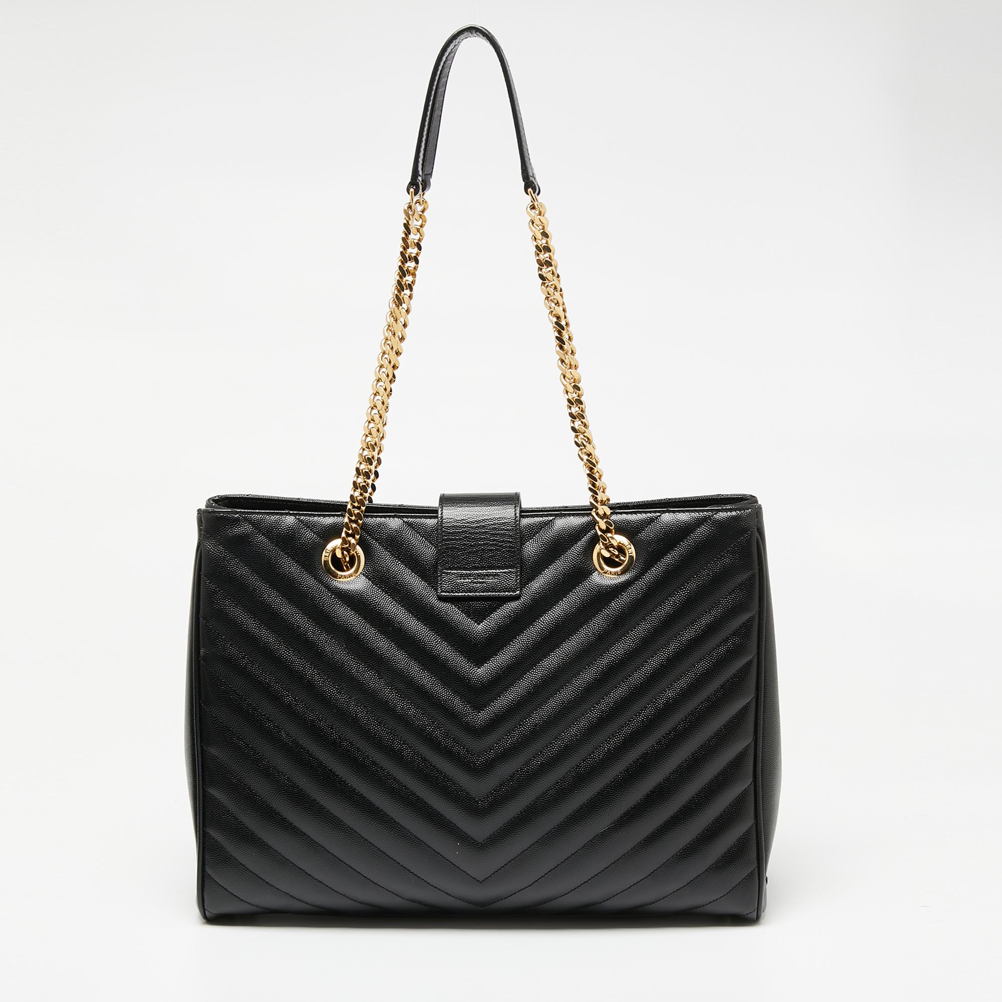 This exquisite tote from Saint Laurent is a chic accessory that represents the brand's rich aesthetics and elegant designs. Crafted from black leather, this easy-to-carry bag has a flap style with the YSL logo in gold-tone on the front. The
