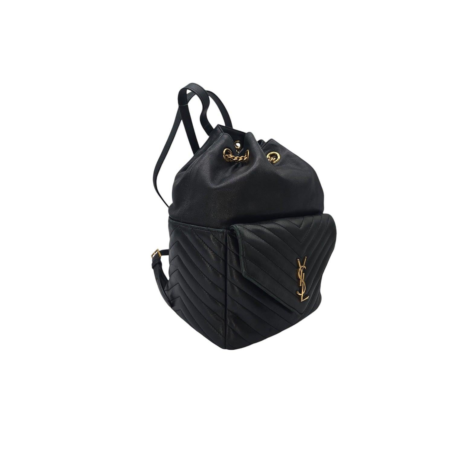 Ce sac à dos en cuir d'agneau noir du designer YSL Saint Laurent est doté d'un cordon de serrage en chaîne qui s'insère dans des bretelles en cuir pour un look à la fois classique et moderne. L'intérieur spacieux en tissu et la poche intérieure
