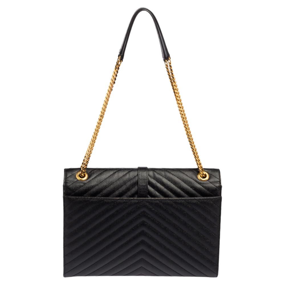 Fashioned using black chevron-quilted leather into a structured silhouette, this Saint Laurent shoulder bag has high style and a timeless charm. It has a flap design and the front is highlighted with a gold-tone YSL logo. The interior is lined with