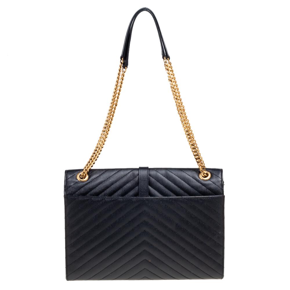 Fashioned using chevron-quilted leather into a structured silhouette, this Saint Laurent Monogram Envelope shoulder bag has high style and a timeless charm. It has a flap design and the front is highlighted with a gold-tone YSL logo. The interior is