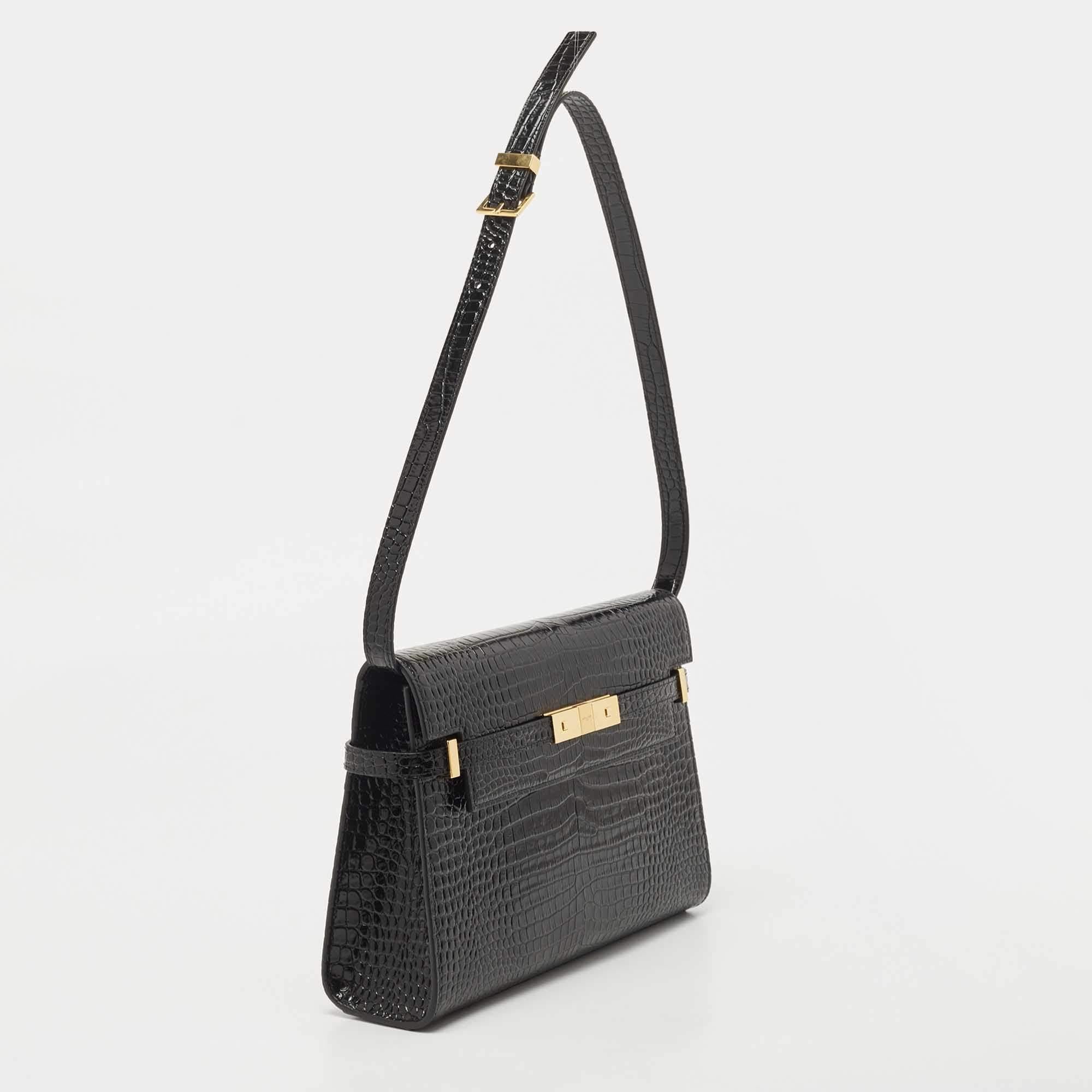 The Saint Laurent Manhattan shoulder bag is a luxurious and sophisticated accessory. Crafted from high-quality black croc-embossed leather, it exudes elegance and style. The design features a sleek silhouette, a fold-over flap with magnetic closure,