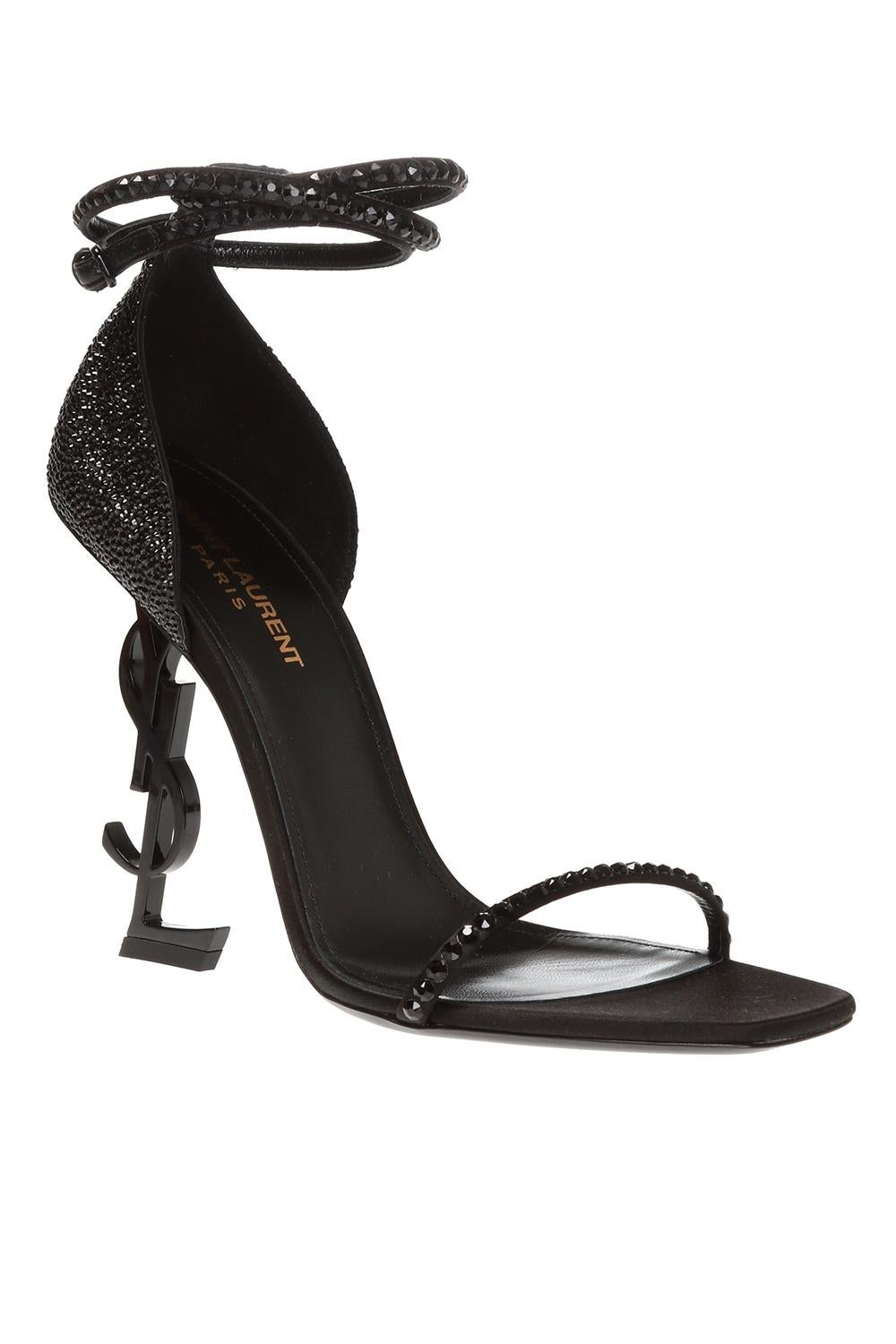 Saint Laurent Black Crystal Embellished Opyum 110 Heeled Sandal

Black Opyum 110 Sandal from Saint Laurent featuring a wrap around adjustable ankle strap, black crystal embellishments, a YSL monogram heel, a square toe, and a strappy sandal
