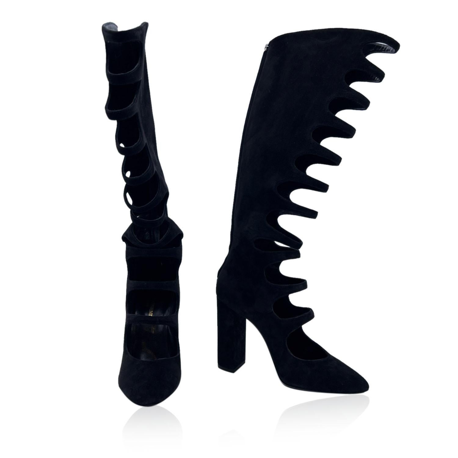 Stunning Saint Laurent Cage Knee-High Boots. Crafted in black suede with cut out details. They feature almond toe, ear zip closure and chunky high covered heels. Leather sole. Heels Height: 4 inches - 10.2 cm. Made in Italy. Size:39 (The size shown