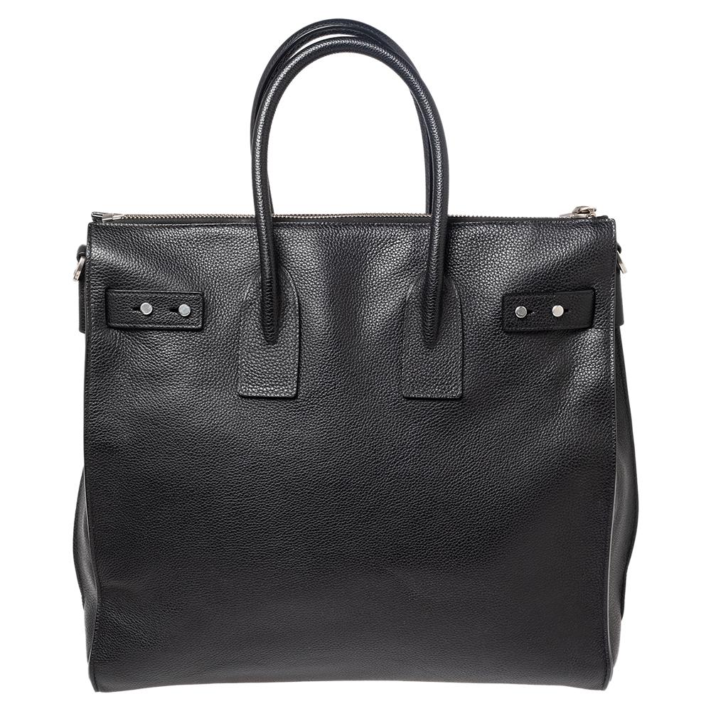 This Sac de Jour tote by Saint Laurent has a structure that simply spells sophistication. Crafted from leather in a black shade, the bag is held by double top handles. The tote comes with a fabric-lined interior with enough space to store your
