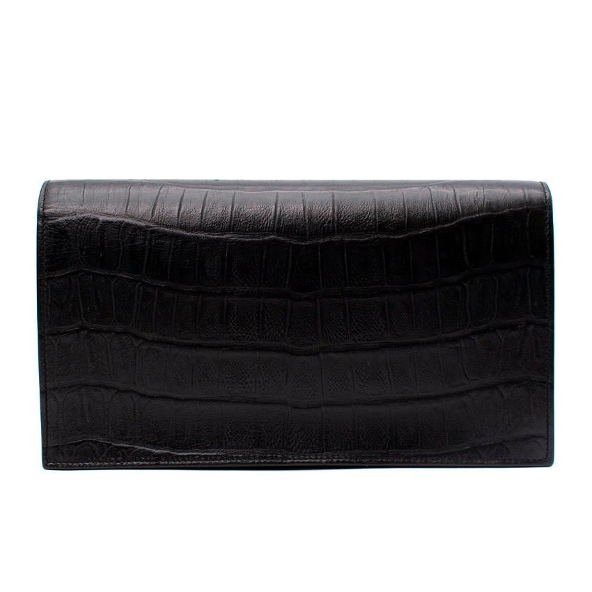  Saint Laurent Black Leather Embossed Crocodile Clutch Bag
 

 - Edgy, black embossed croc leather clutch, with silver-tone metal edge plate with debossed brand logo
 - Magnetic flap closure
 - Gusseted style, with a black suede interior featuring