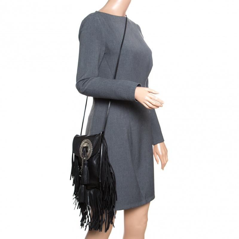 How gorgeous is this bag from Saint Laurent! It carries an outstanding design and a fabulous interplay of classic black leather and silver-tone hardware. It has a spacious suede-lined interior and it is held by a slender strap. The tassel detailing
