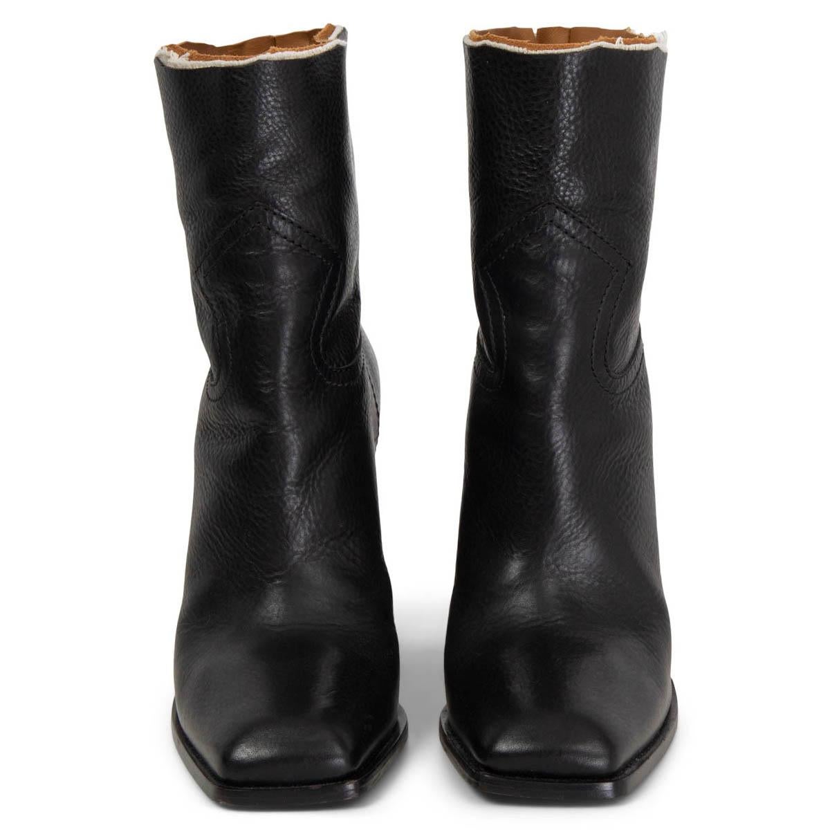 100% authentic Saint Laurent Jodie 105 western ankle boots in black calfskin with a raw cut-off top edge with off-white canvas and camel smooth leather lining. Boots feature a square toe and heel. Have been worn once or twice and are in excellent