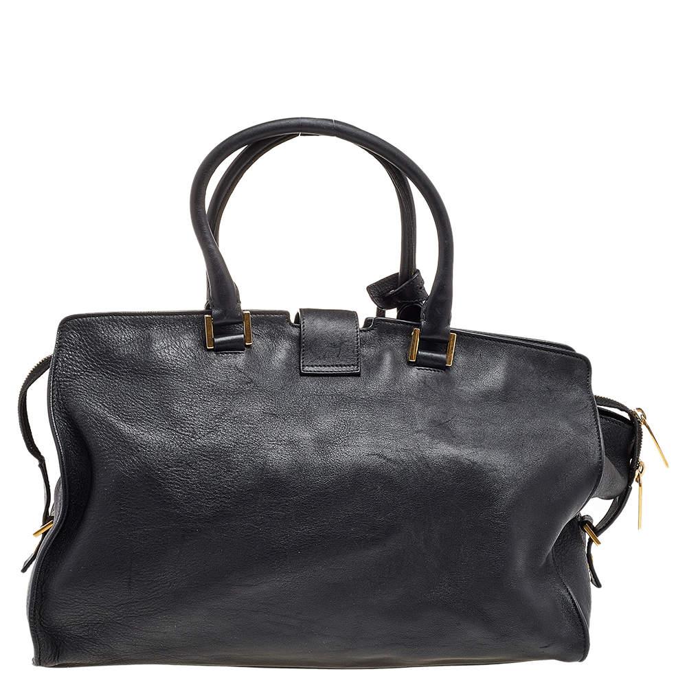 This elegant black Cabas Chyc tote from Saint Laurent is ideal for everyday use. Crafted from leather, the bag is detailed with a gold-tone Y motif snap closure and dual-rolled handles. The top zip closure opens to a spacious interior perfectly