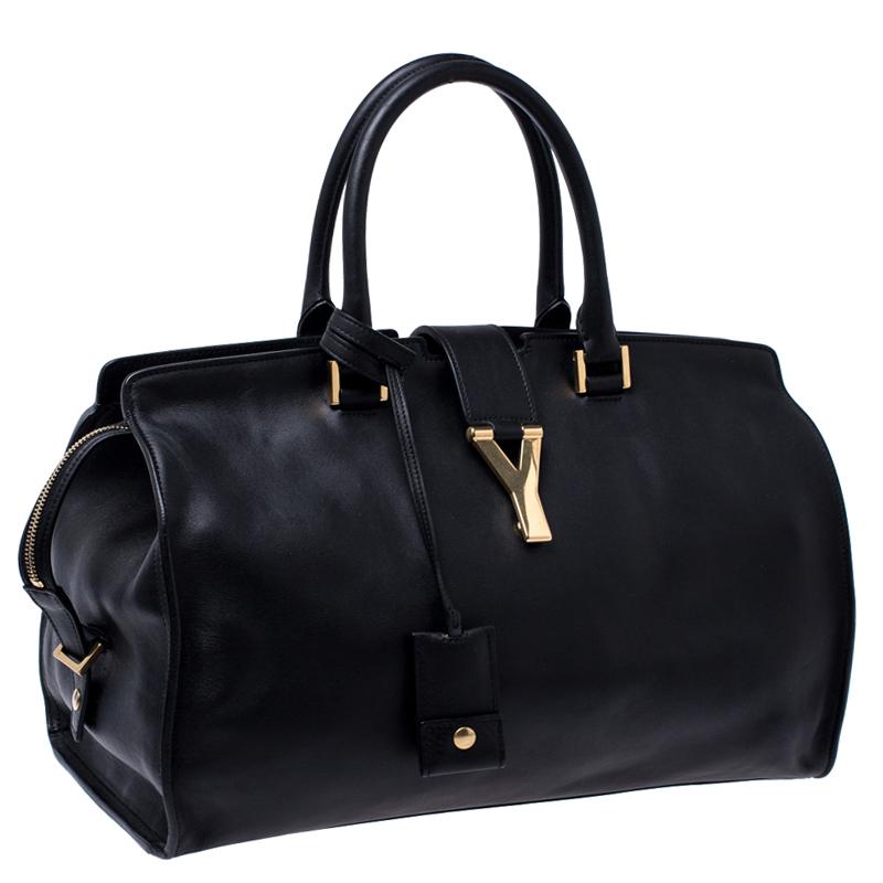 This elegant black Cabas Chyc tote from Saint Laurent is ideal for everyday use. Crafted from leather, the bag is detailed with a gold-tone Y motif snap closure and dual-rolled handles. The top zip closure opens to a spacious interior that is