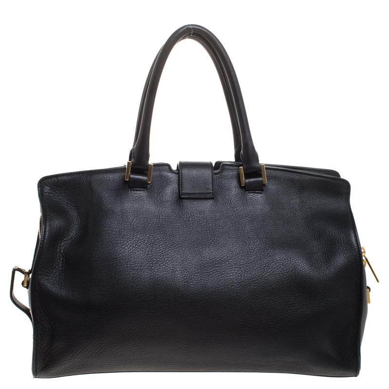 This elegant black Cabas Chyc tote from Saint Laurent is ideal for everyday use. Crafted from leather, the bag is detailed with a gold-tone Y motif snap closure and dual-rolled handles. The top zip closure opens to a spacious interior that is